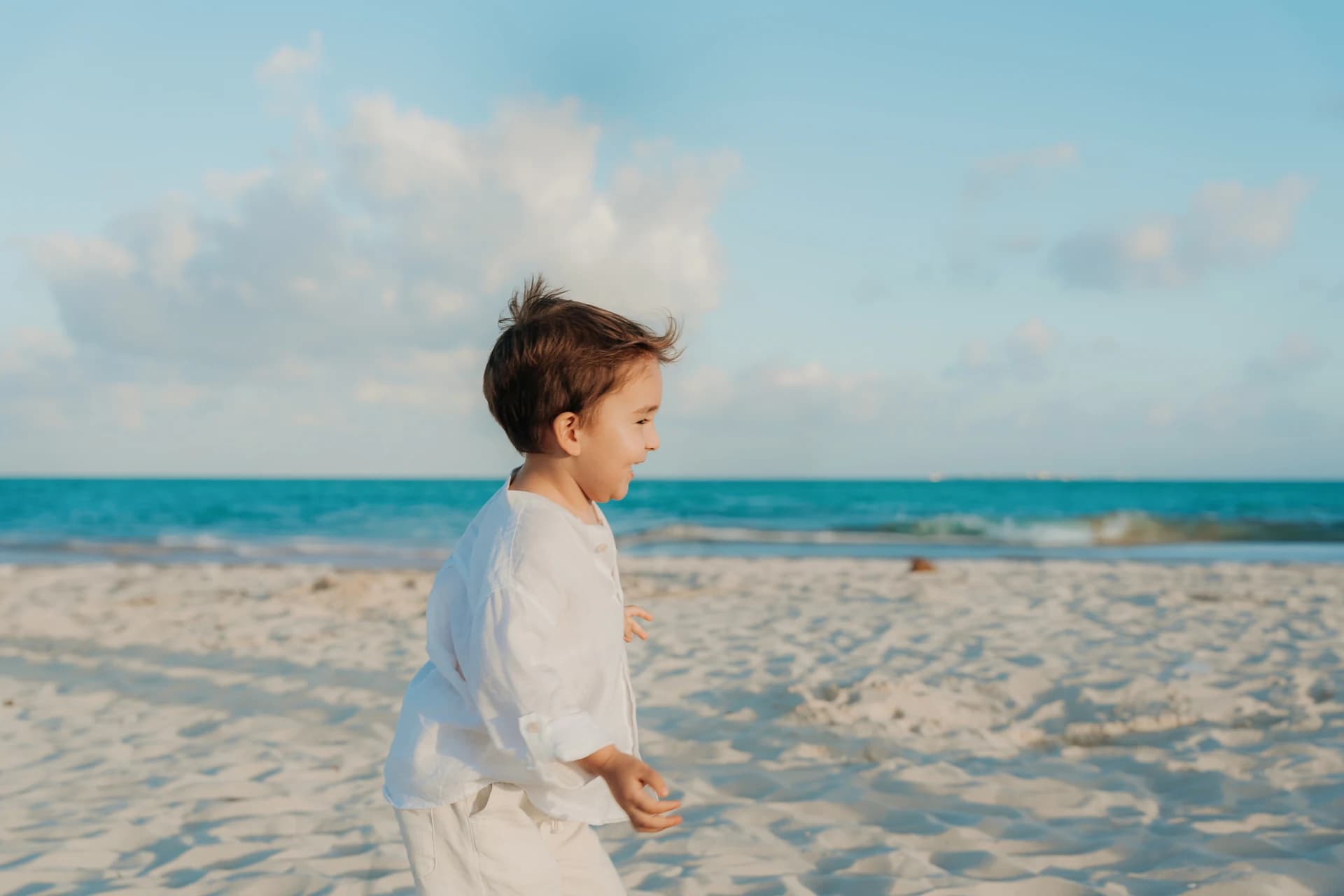 Young boy running on a Cancún beach