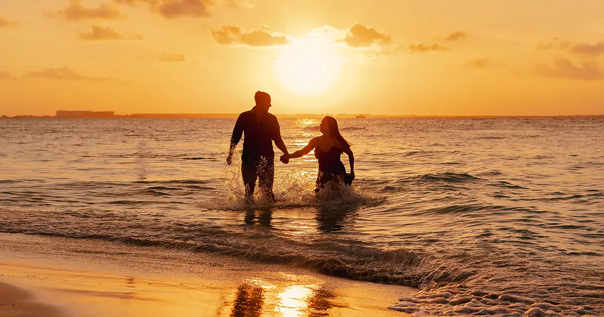 Couple silhouette in the ocean at golden hour — Riviera Maya lifestyle photography