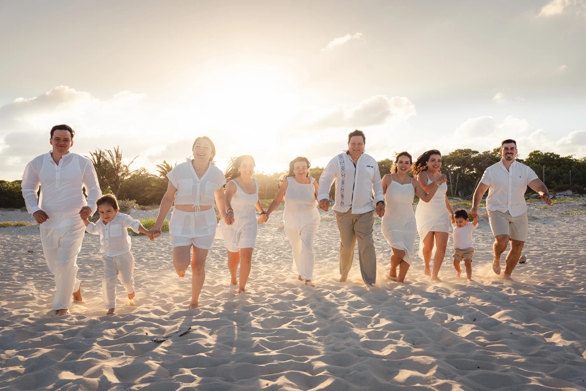 Family walking a Cancún beach in warm golden-hour light, long shadows across the sand