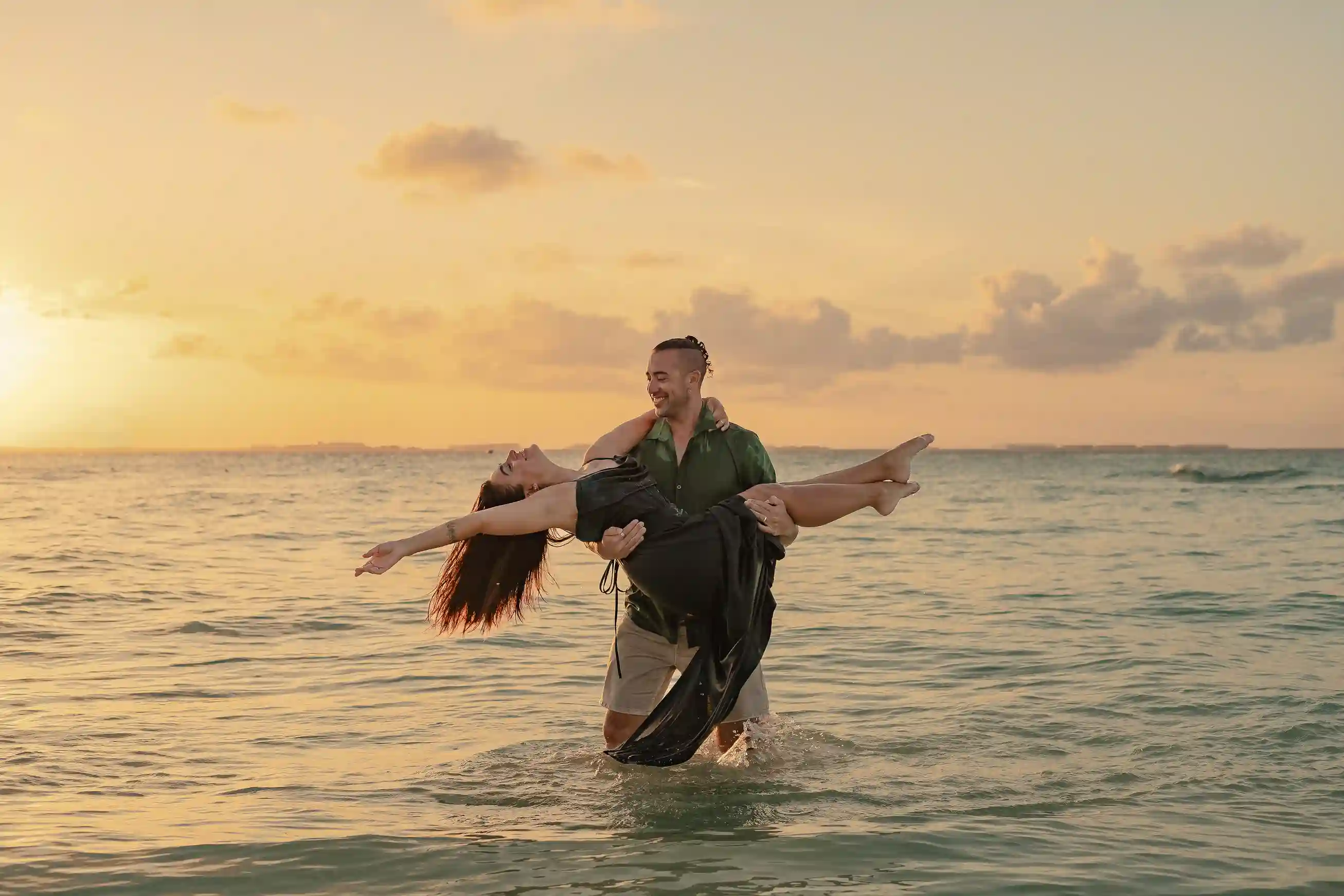 Couple in linen outfits on Cancún beach during golden hour beach photoshoot, soft warm tones