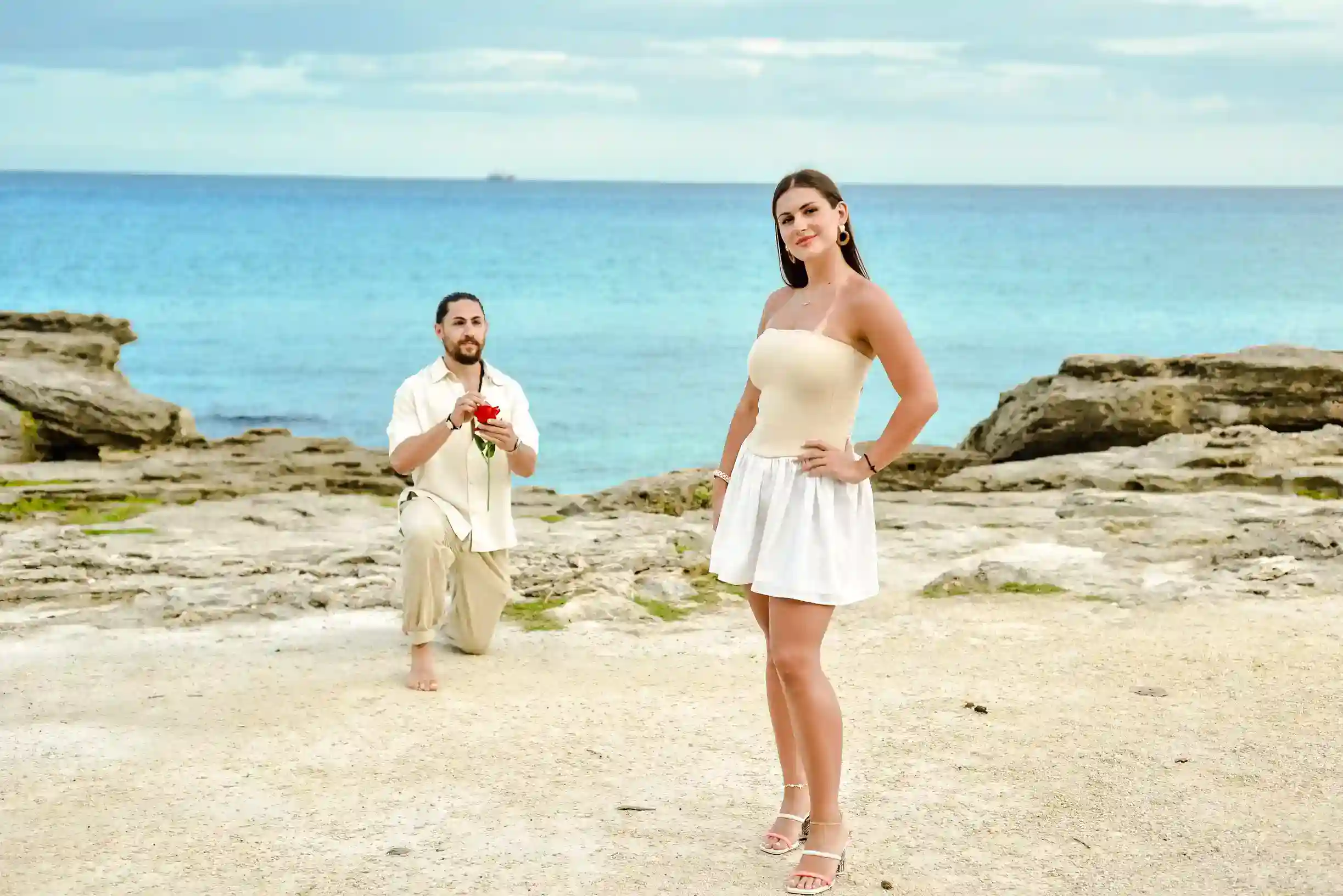 Couple in coordinated neutral outfits during Riviera Maya beach photoshoot at golden hour