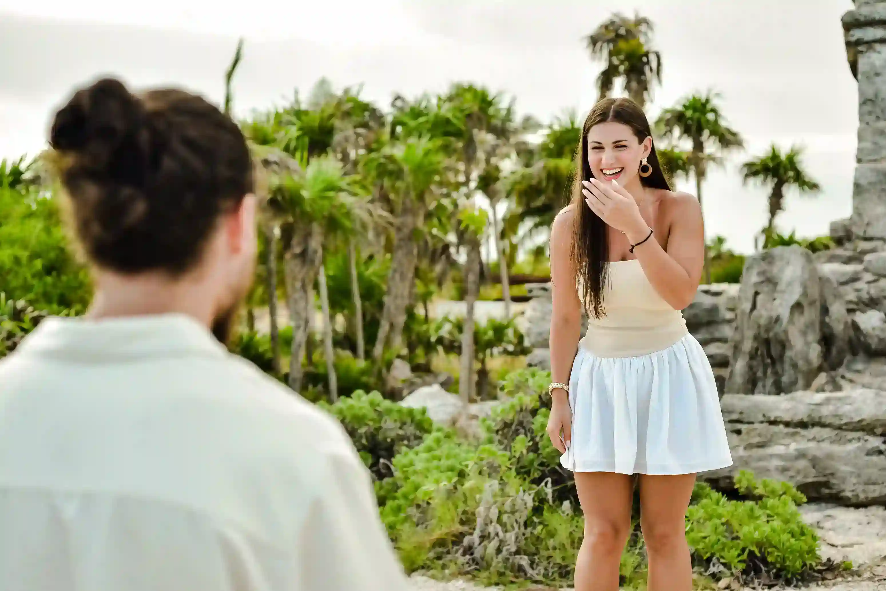 Couple laughing near Tulum ruins during lifestyle photography session