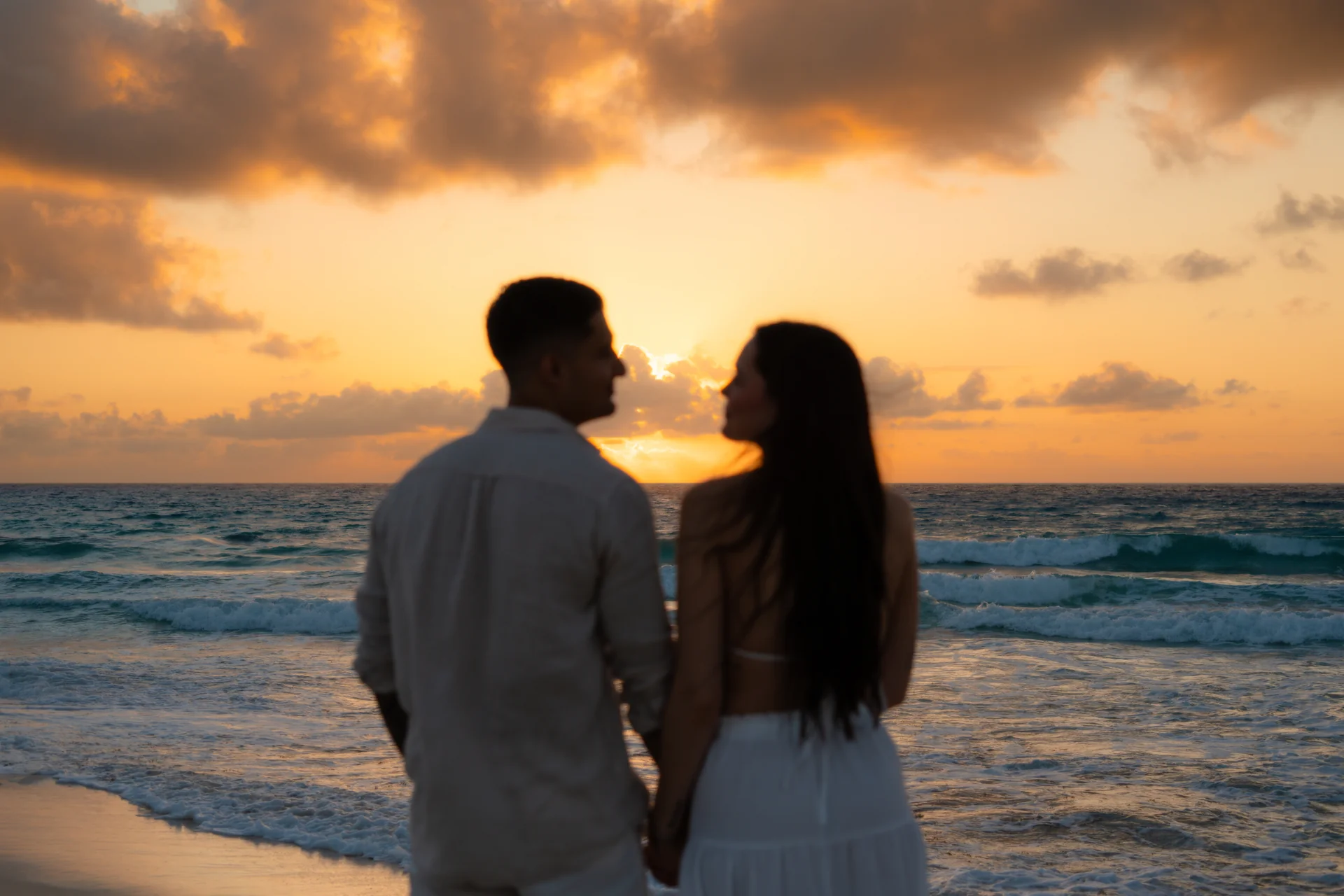 Couple walking together through the shallows, Playa Delfines, Cancún