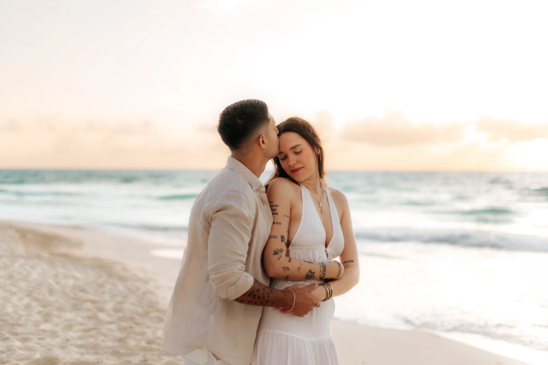Couple sharing a laugh on the sand, Playa Delfines, Cancún