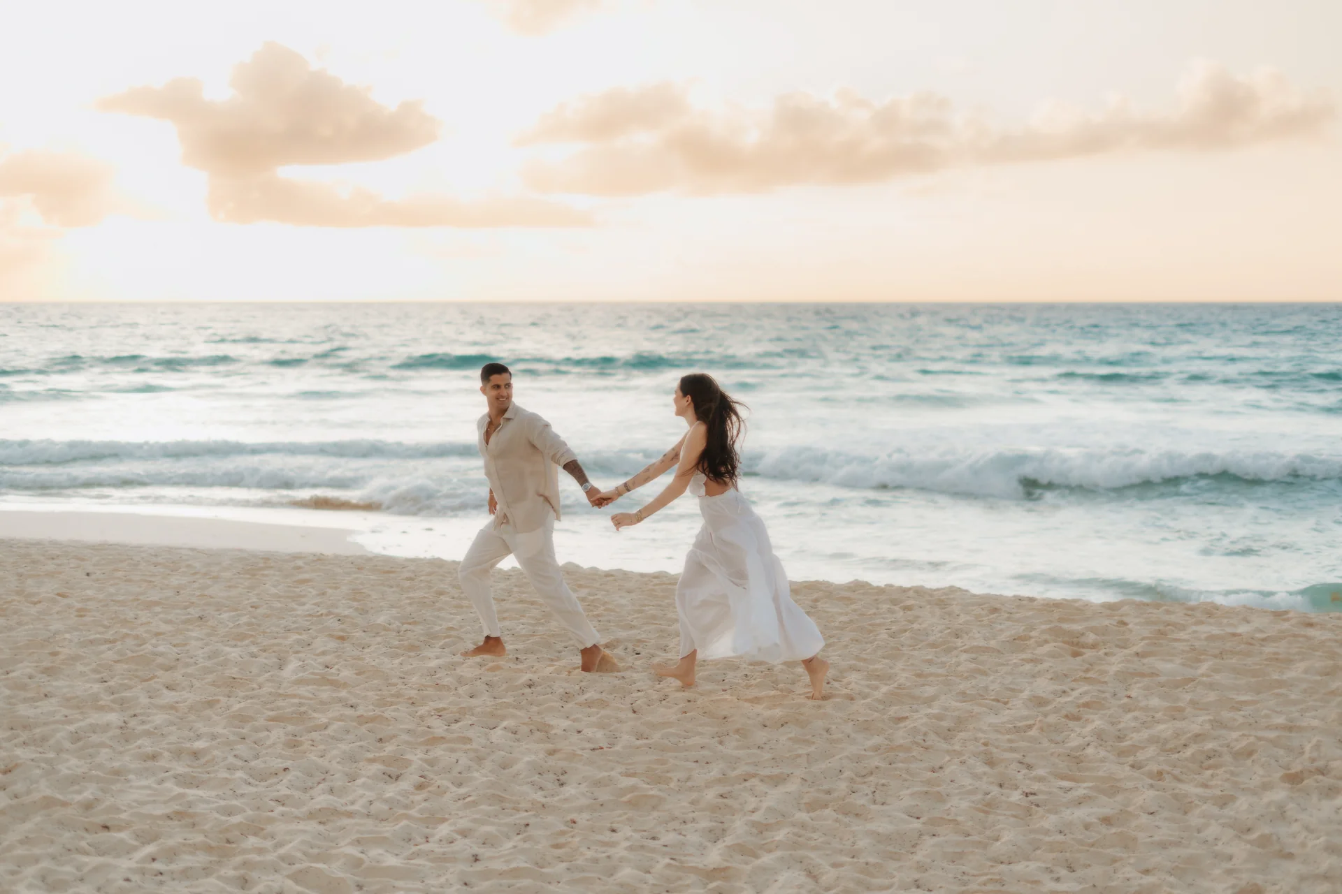 Couple walking the water's edge in the morning, Playa Delfines, Cancún