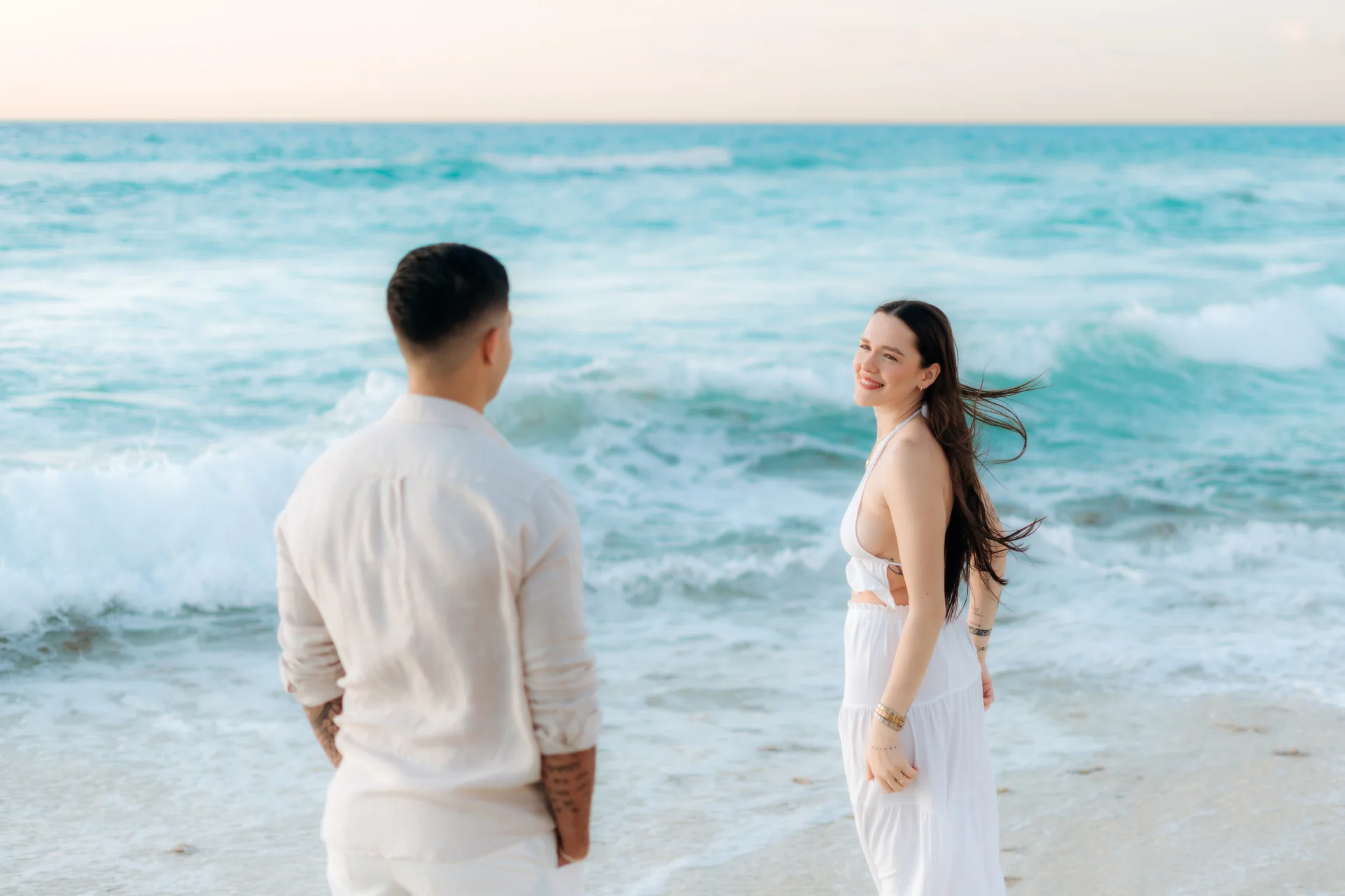 Couple laughing while walking the shore, Playa Delfines, Cancún