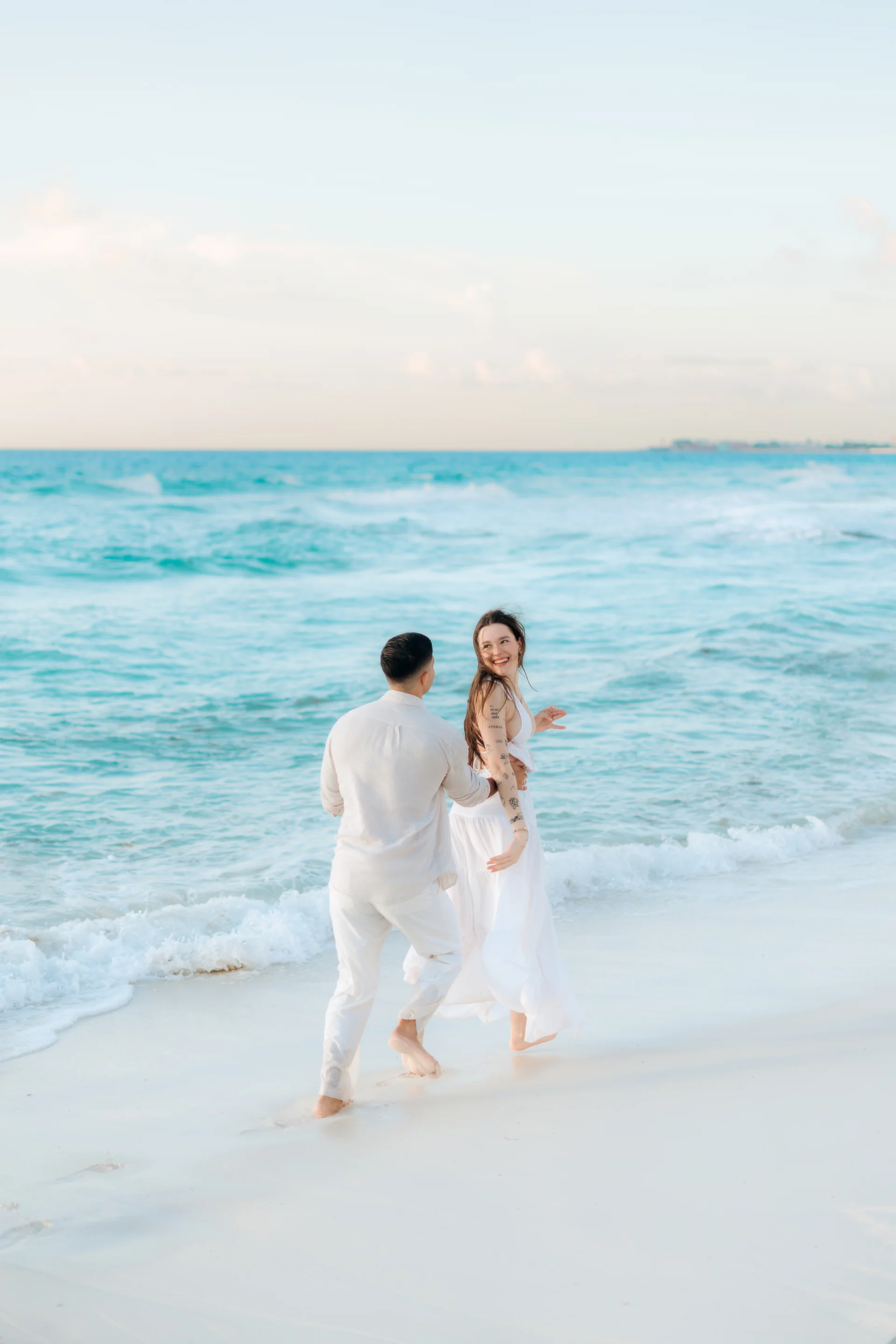 Couple portrait with the ocean behind them, Playa Delfines, Cancún