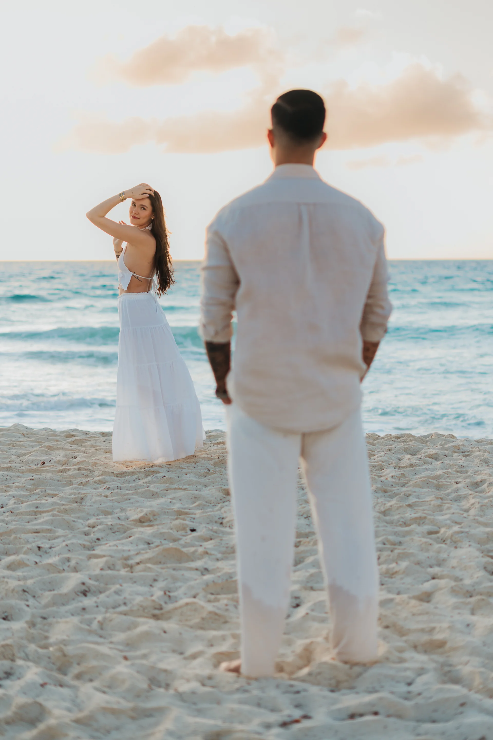 Couple sitting together on the sand, Playa Delfines, Cancún