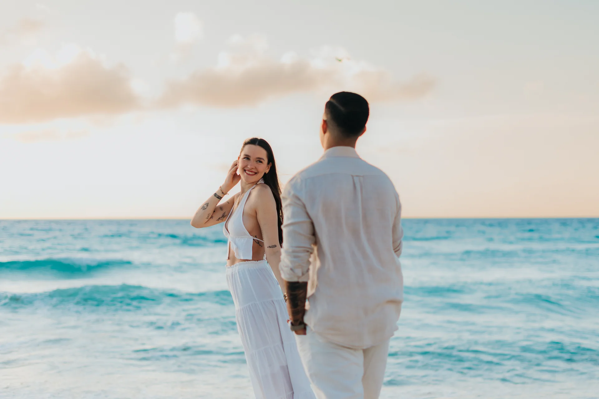 Couple leaning together at the water's edge, Playa Delfines, Cancún