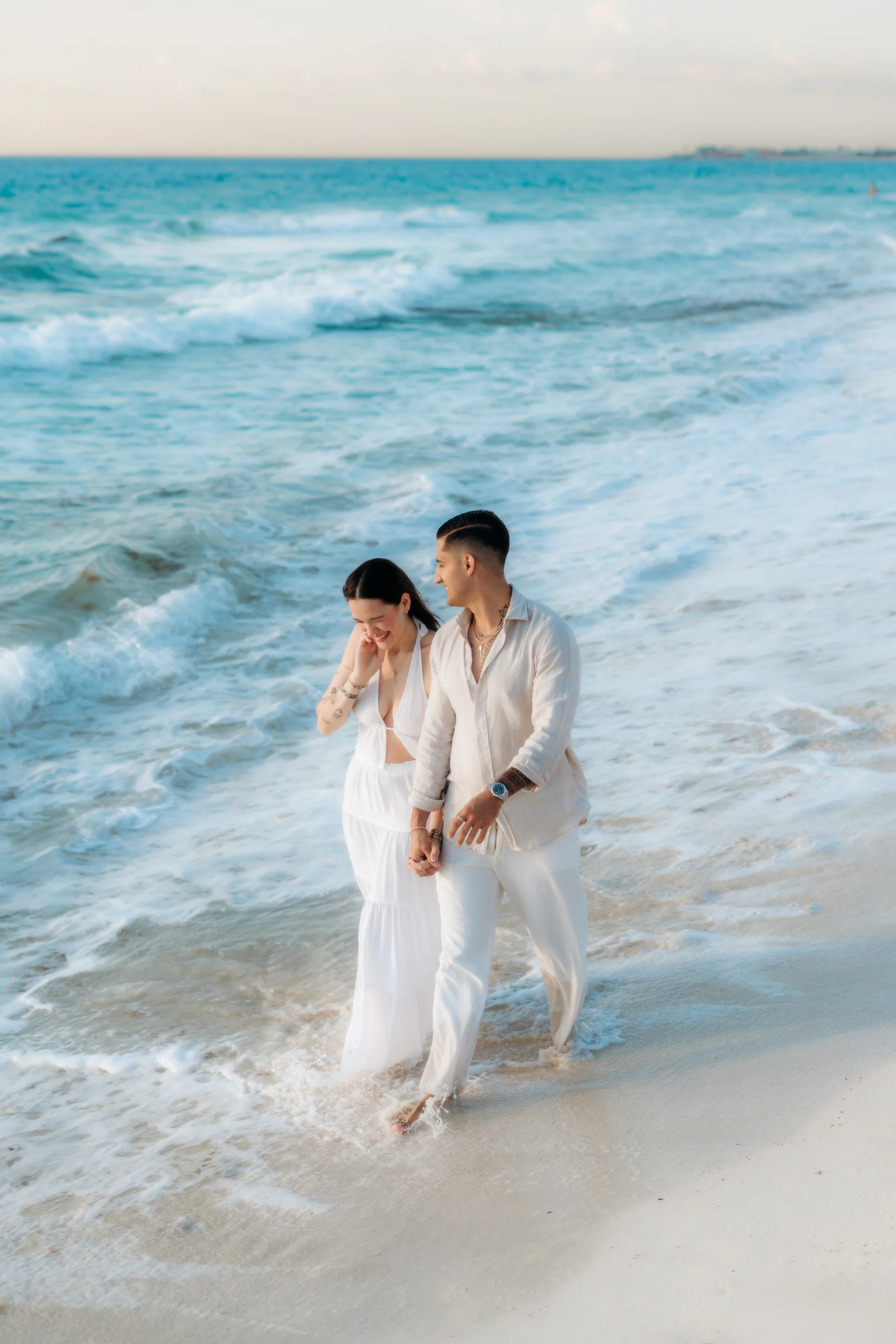 Couple walking barefoot along the surf, Playa Delfines, Cancún