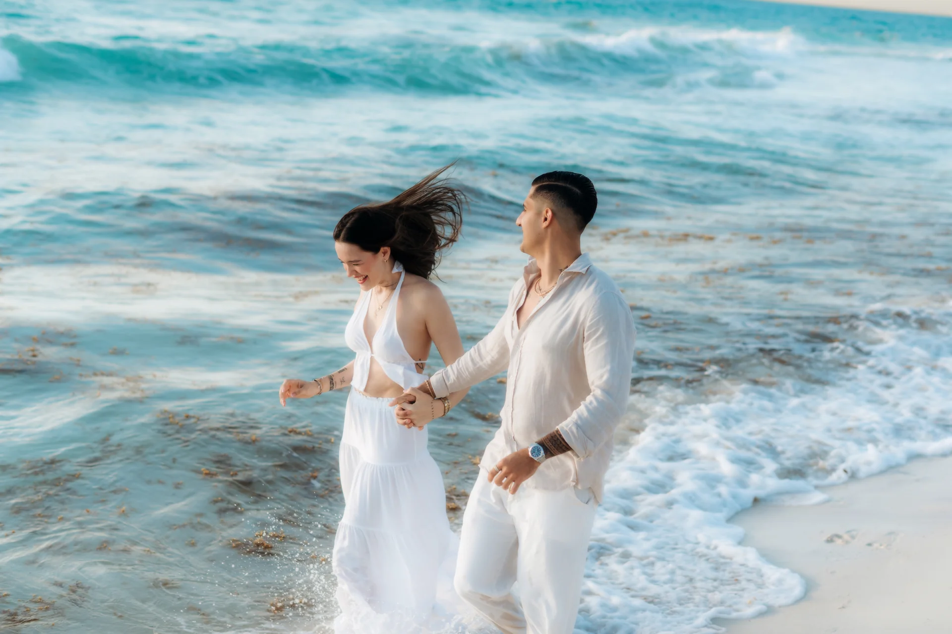 Couple sharing a tender moment on the sand, Playa Delfines, Cancún