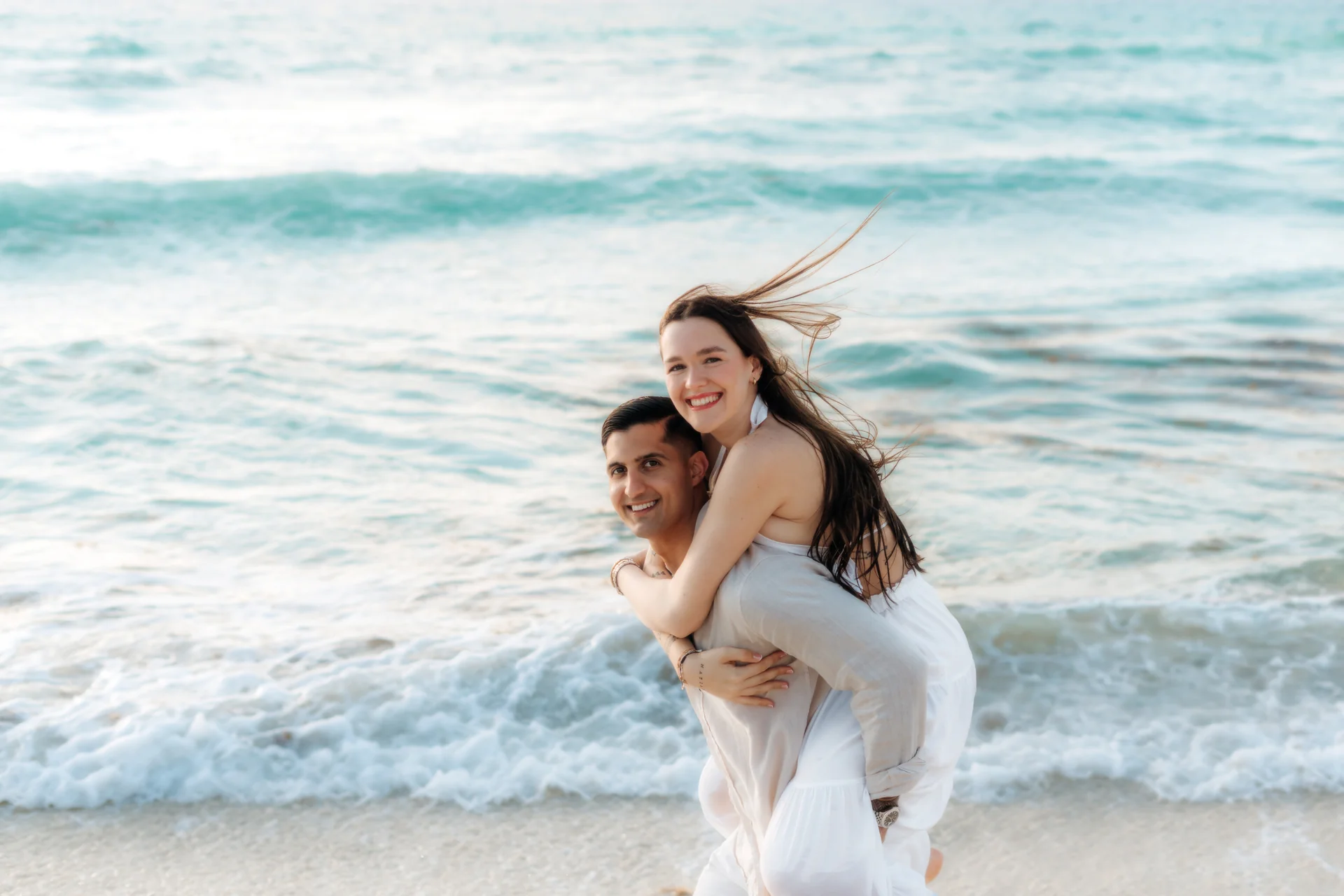 Couple smiling into the morning light, Playa Delfines, Cancún