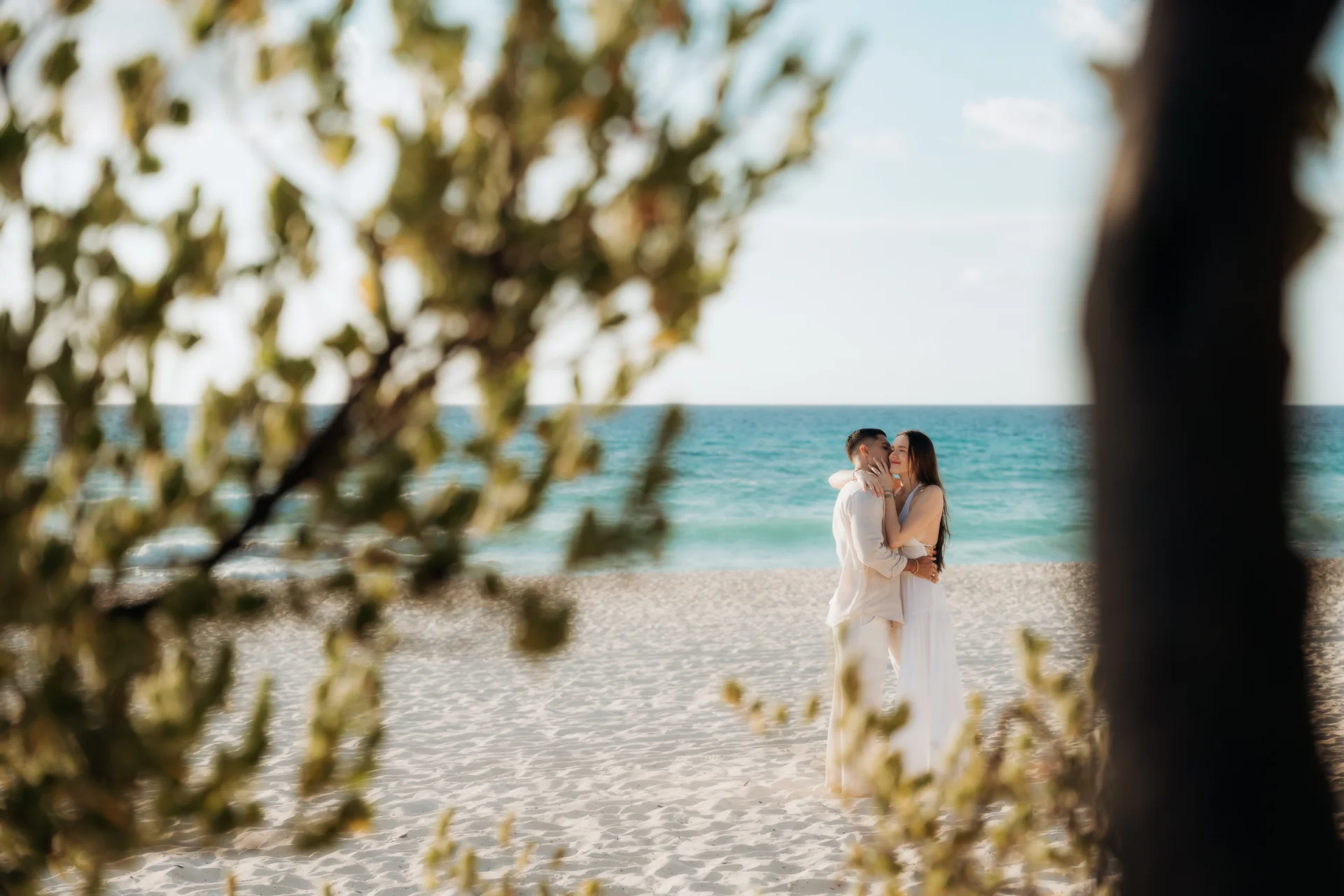 Couple standing forehead to forehead on the sand, Playa Delfines, Cancún
