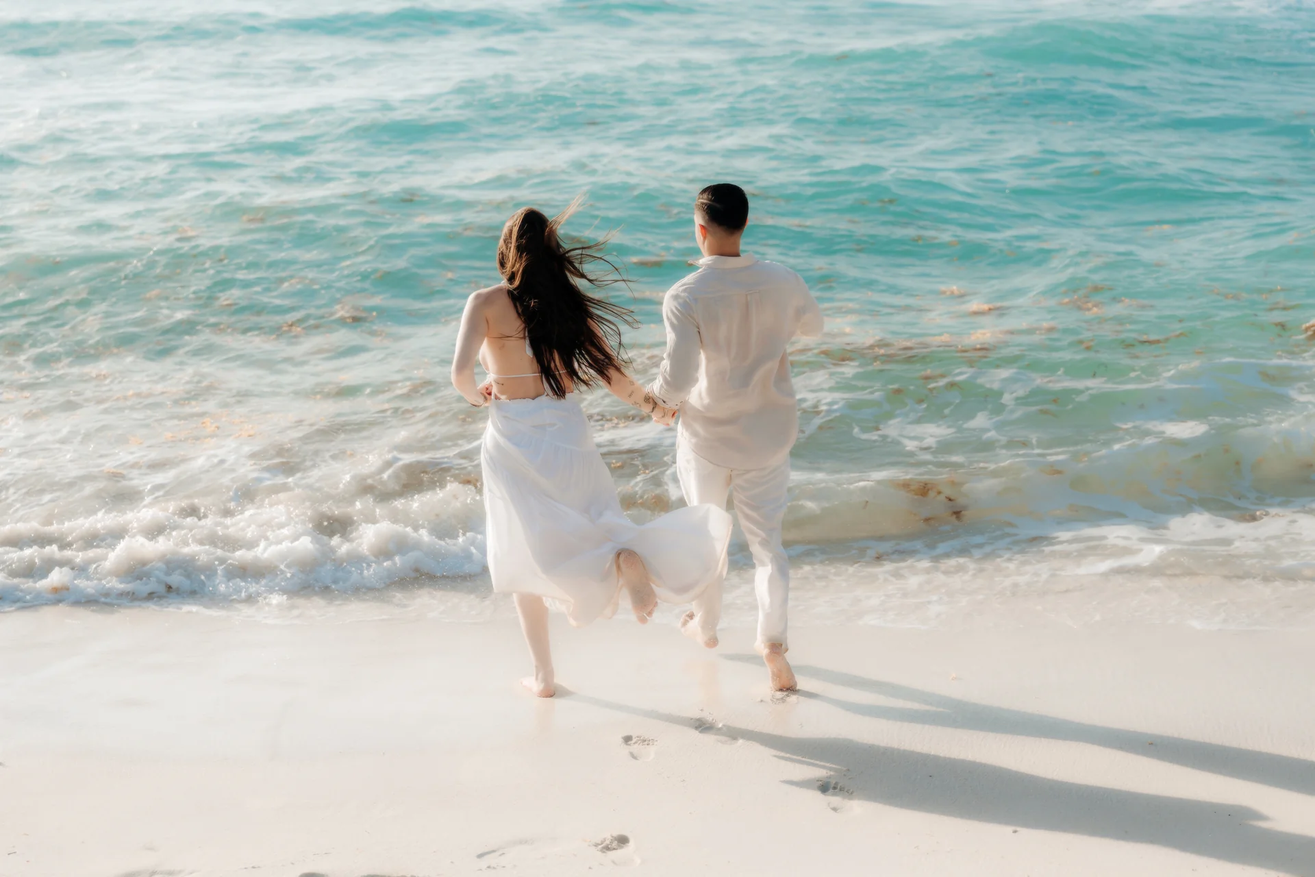 Couple walking away down the beach, Playa Delfines, Cancún