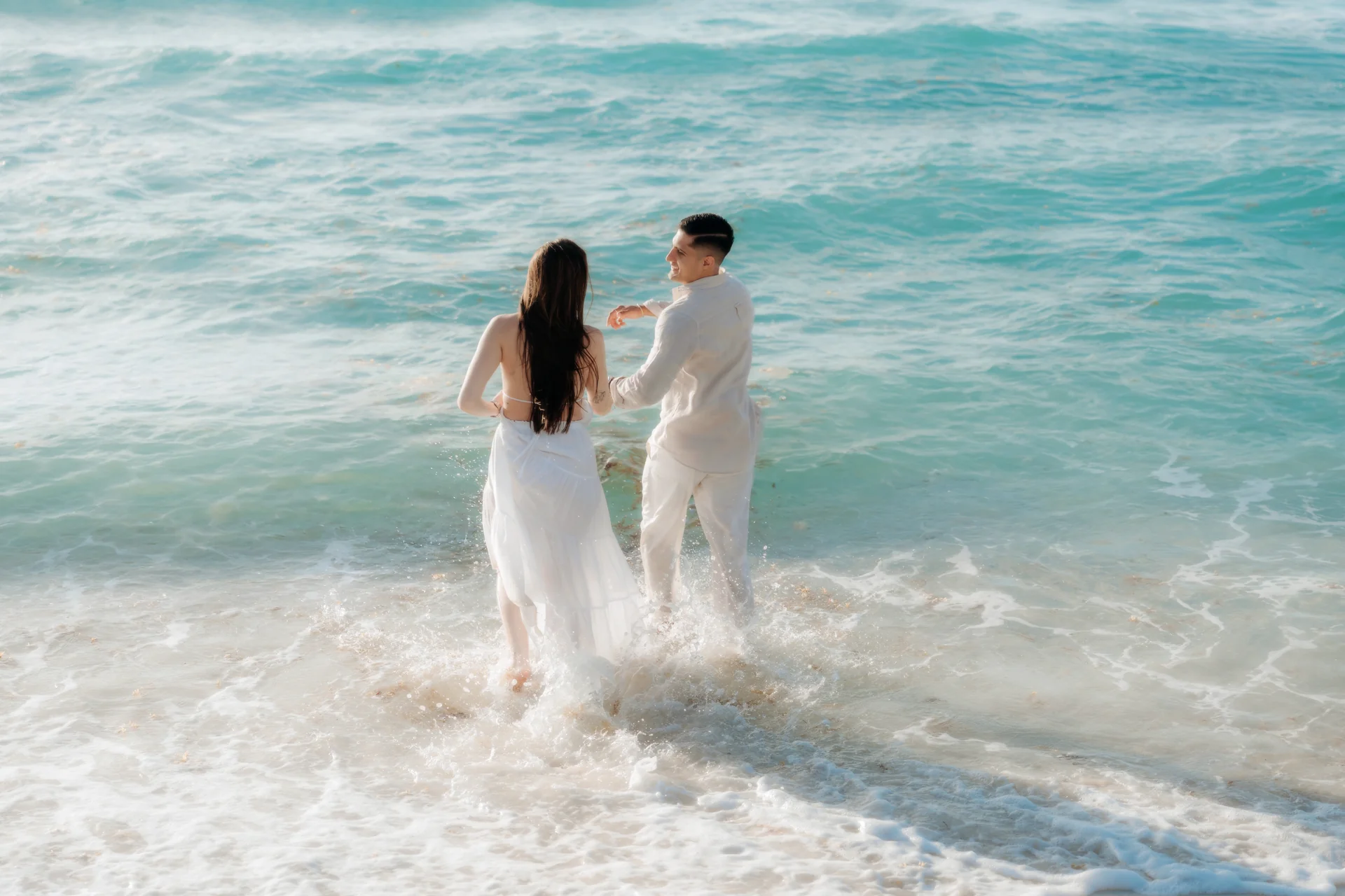 Couple holding each other as the waves roll in, Playa Delfines, Cancún
