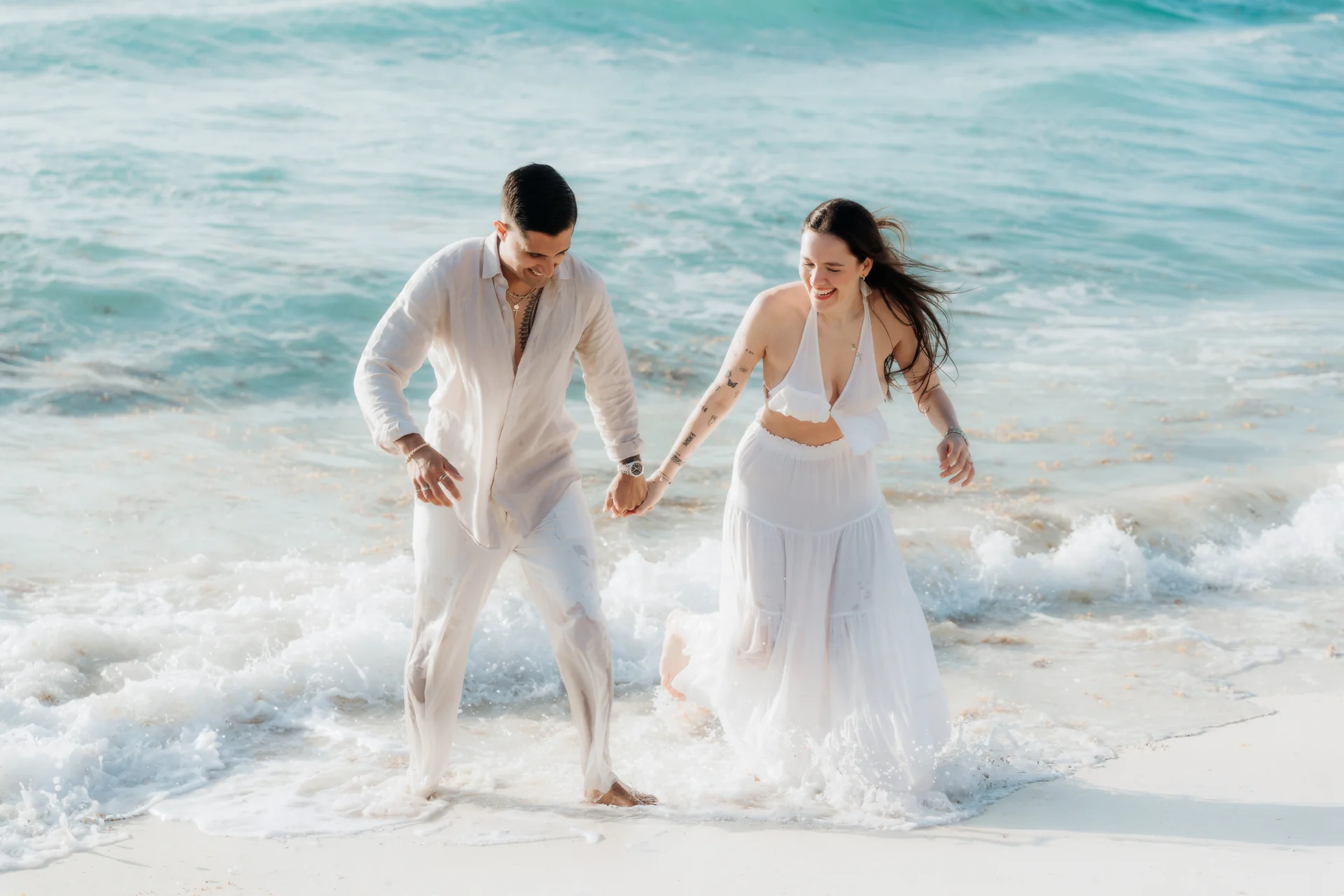 Couple twirling together on the sand, Playa Delfines, Cancún