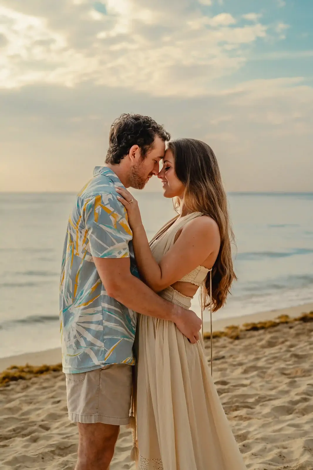 Engaged couple at golden hour on a Cancún beach during an engagement photography session