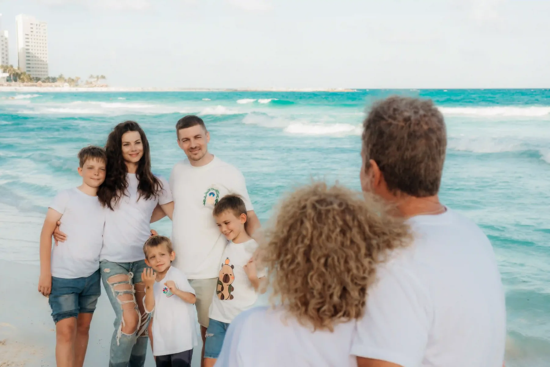 Family on the beach at golden hour during Cancún family photo session