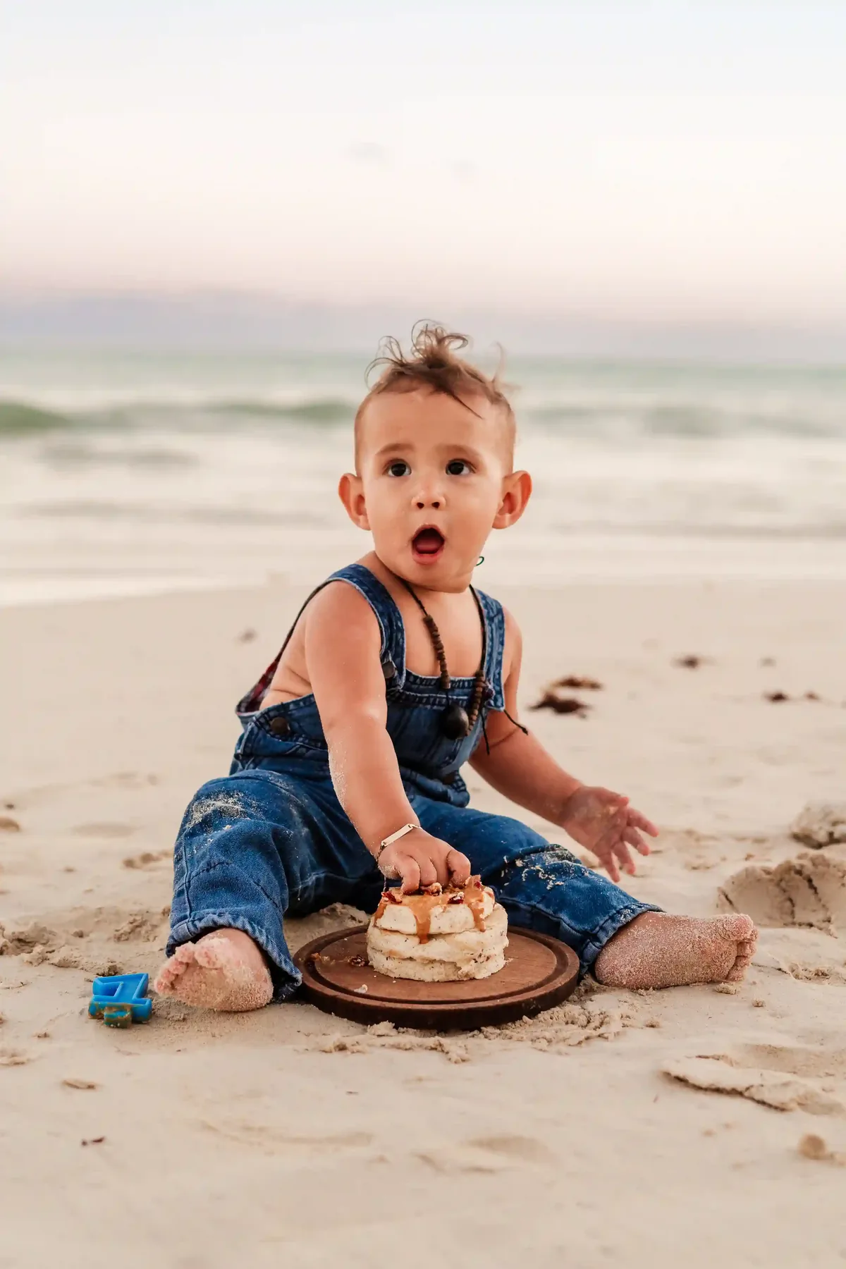 Parents holding baby up to sky during Cancún beach family photoshoot at sunset