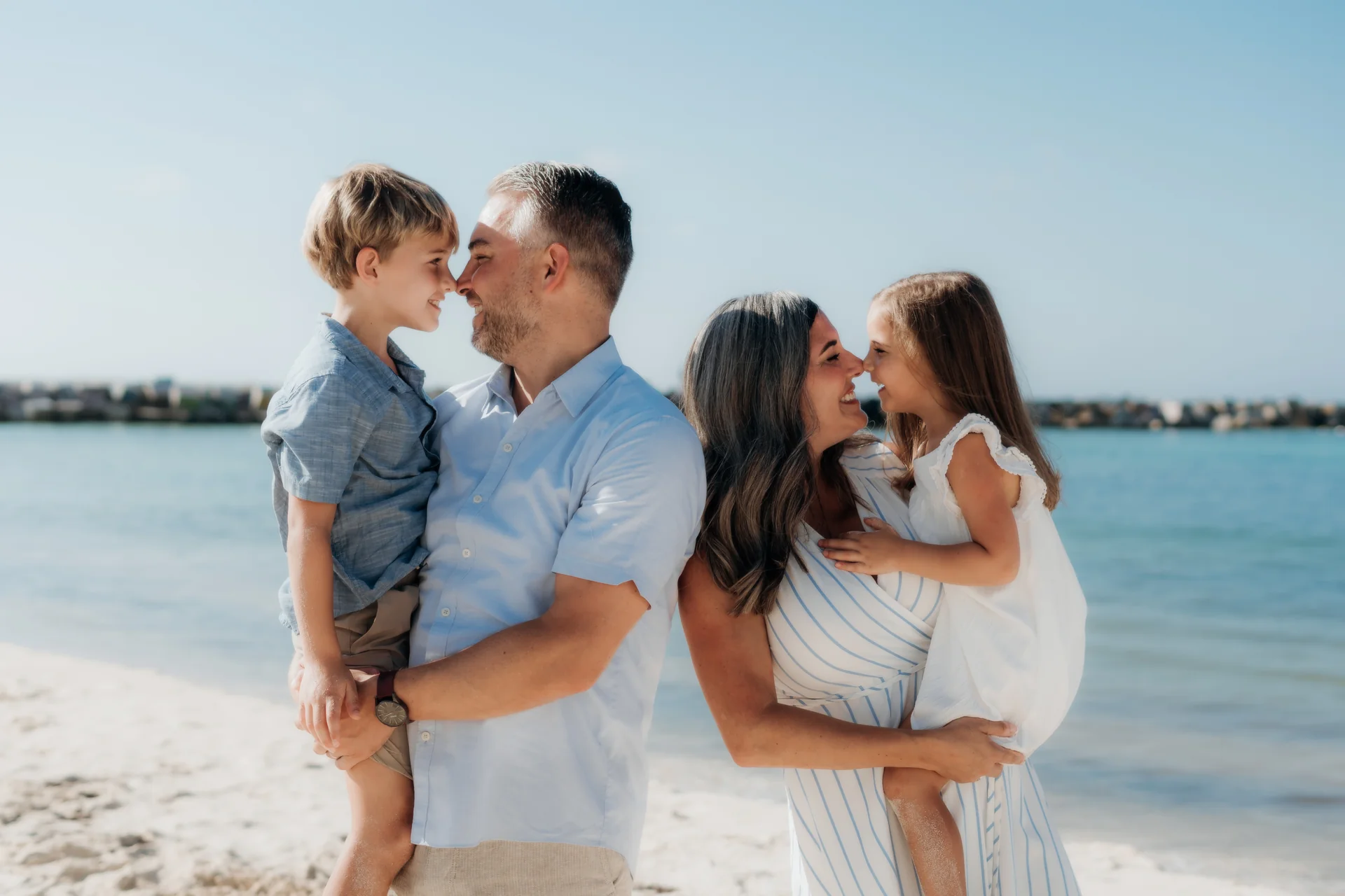 Parents holding their son and daughter close in a tender moment by the sea, Hyatt Ziva, Cancún