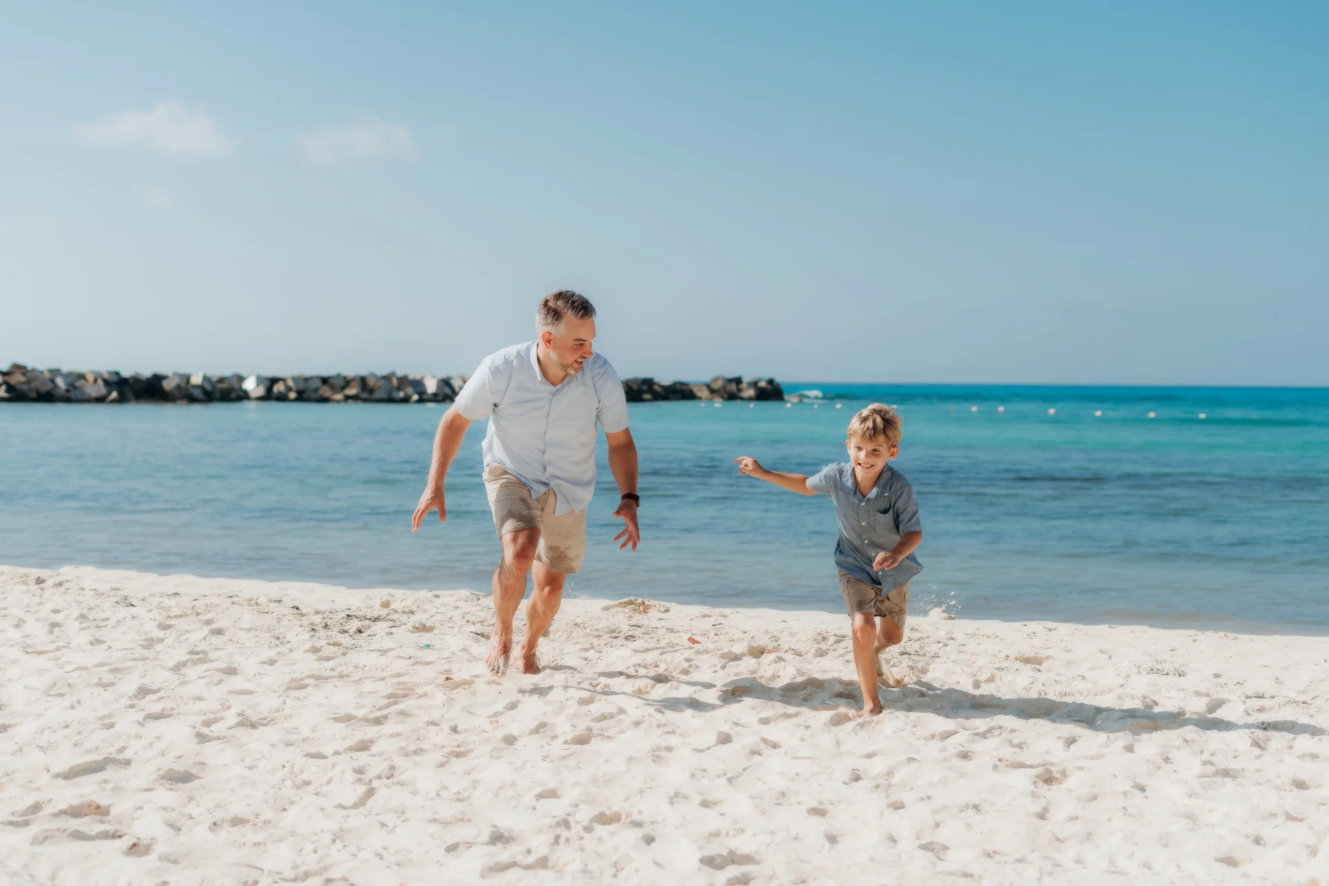 Family sharing a group hug on the sand, Hyatt Ziva, Cancún