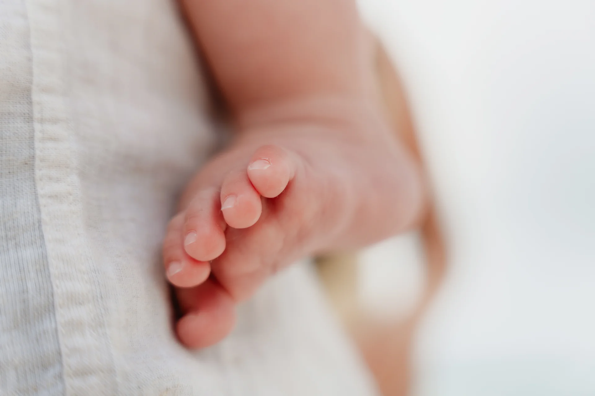 Close-up detail of the baby's bare foot, Playa Delfines, Cancún