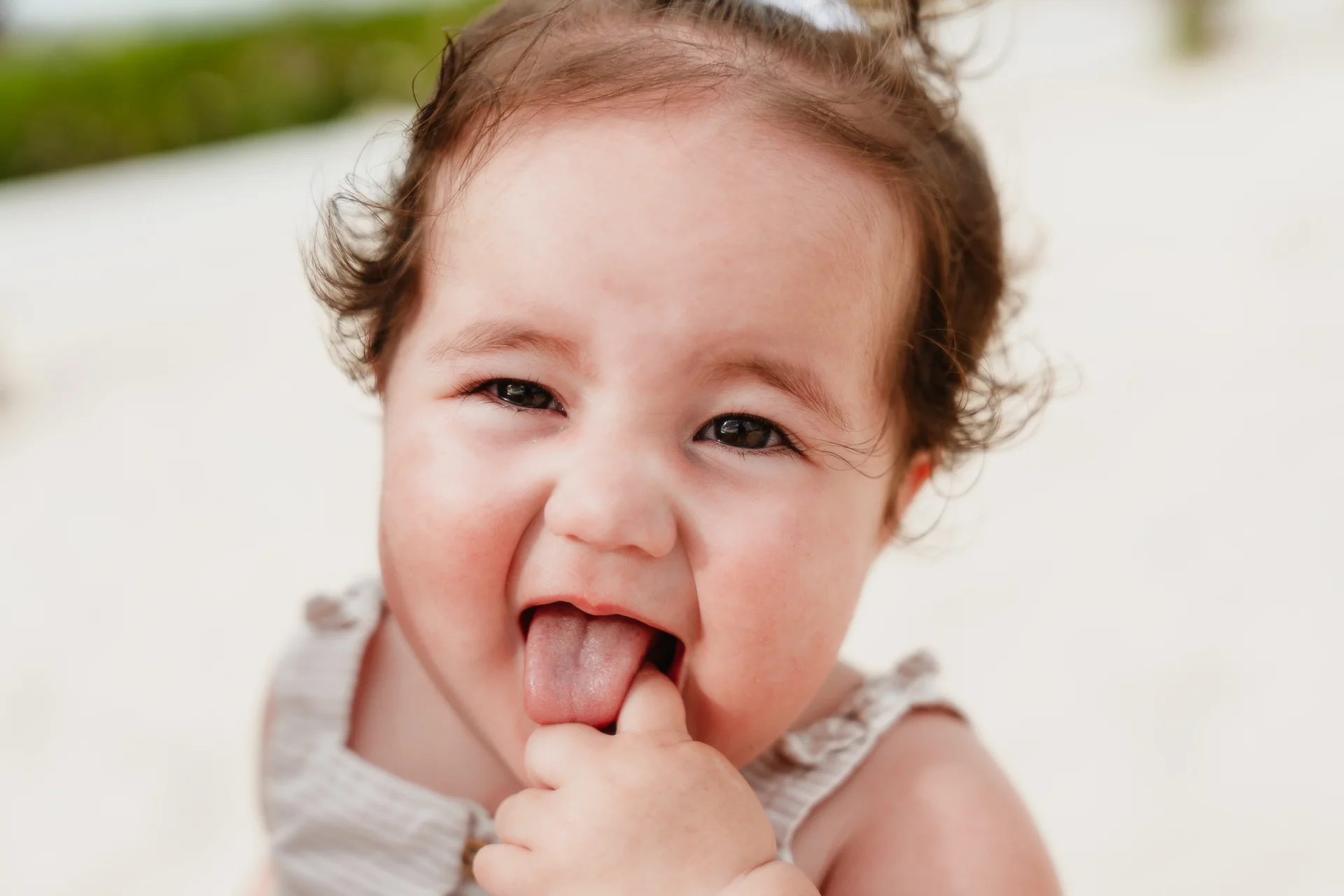 Close-up portrait of the smiling baby girl on the beach, Playa Delfines, Cancún
