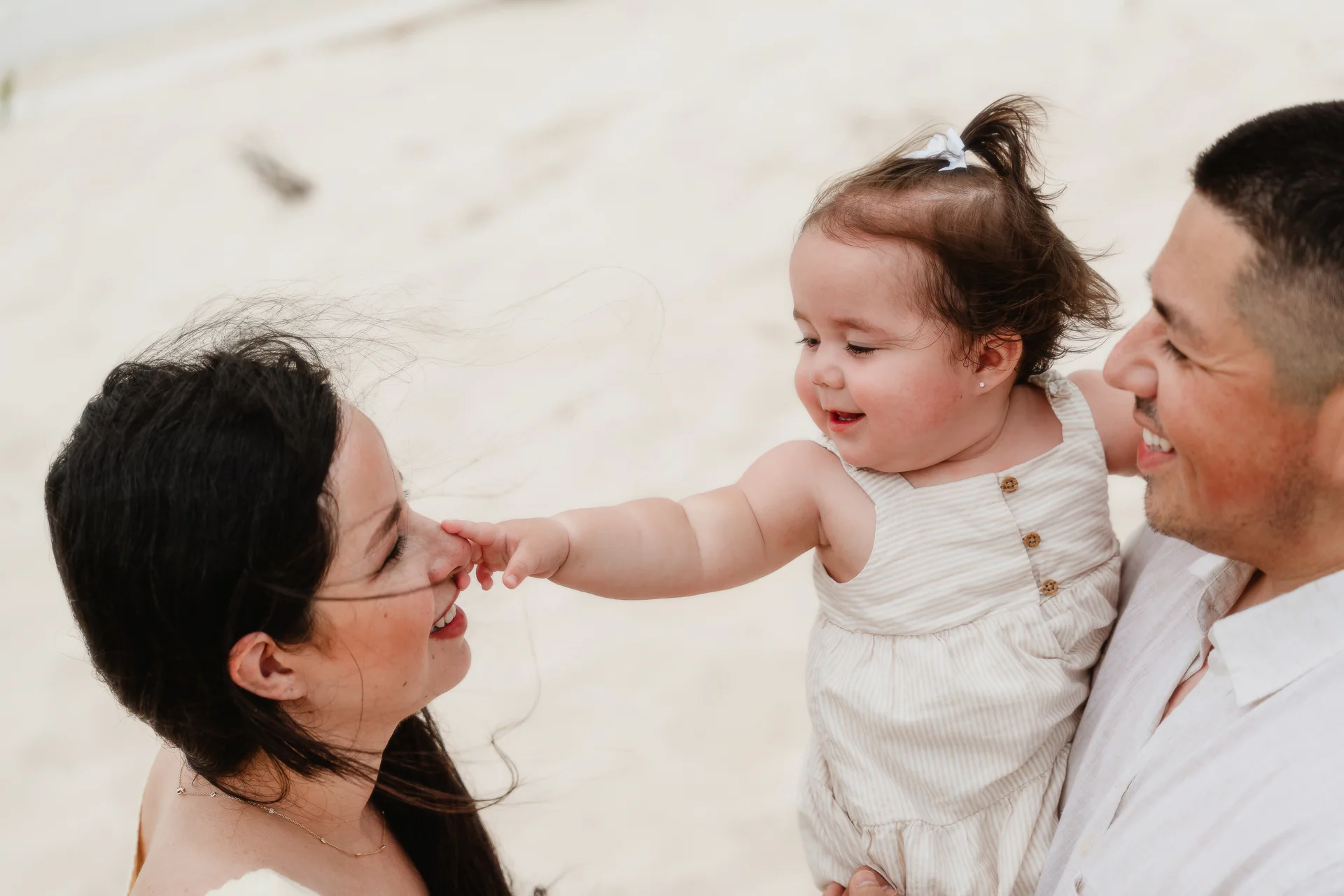 Family laughing together on the sand, Playa Delfines, Cancún