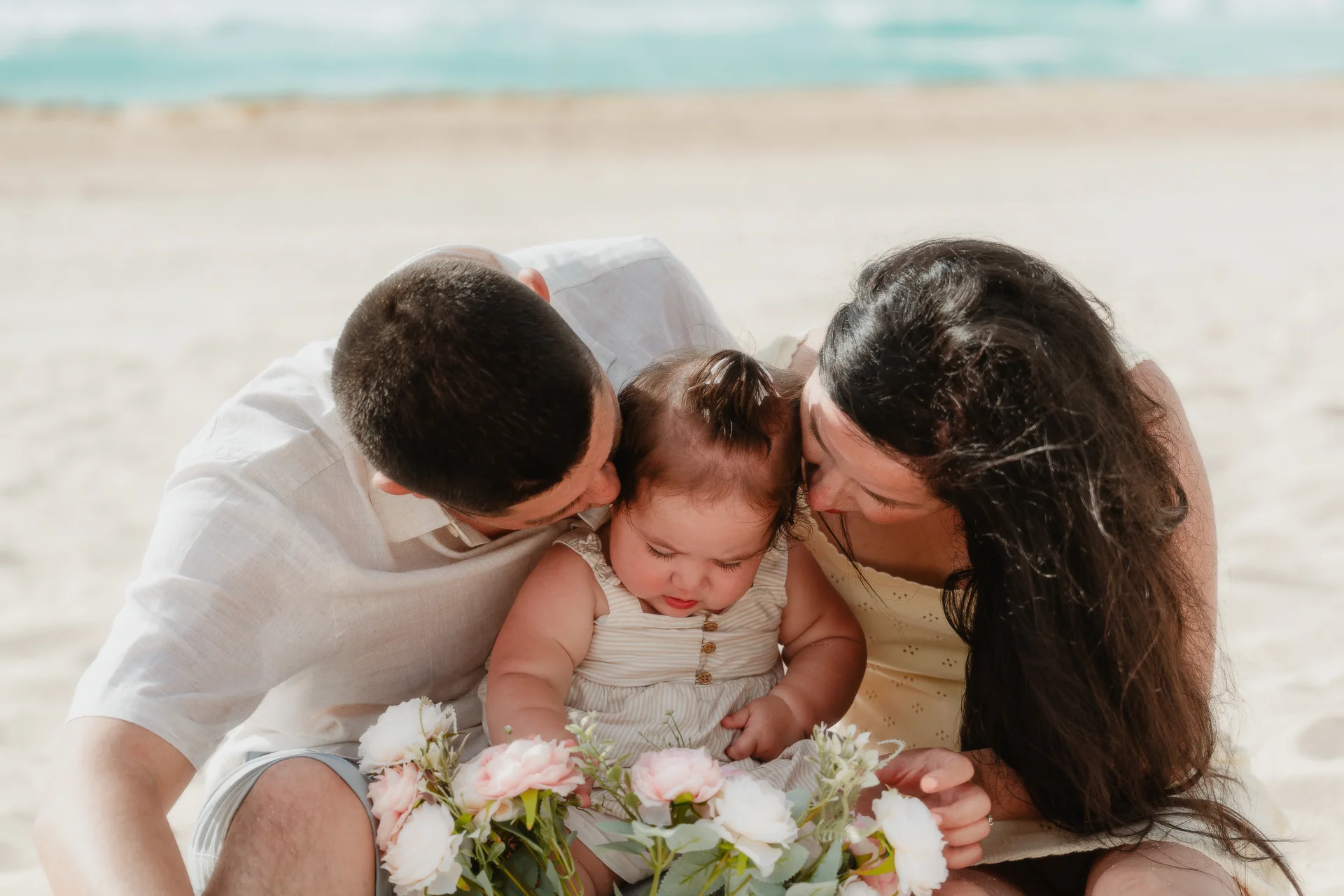 Baby smiling in a parent's arms, Playa Delfines, Cancún