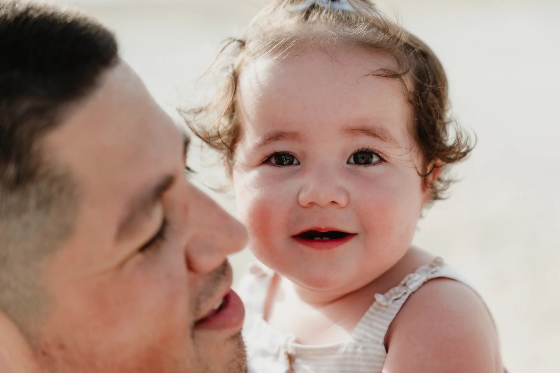 Parents laughing with their child in the breeze, Playa Delfines, Cancún