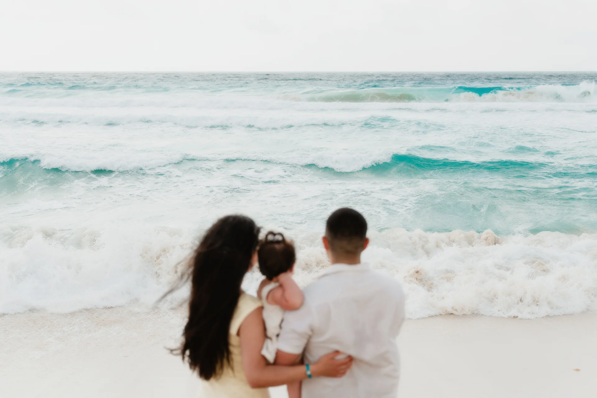 Child tossed gently into the air by a parent, Playa Delfines, Cancún