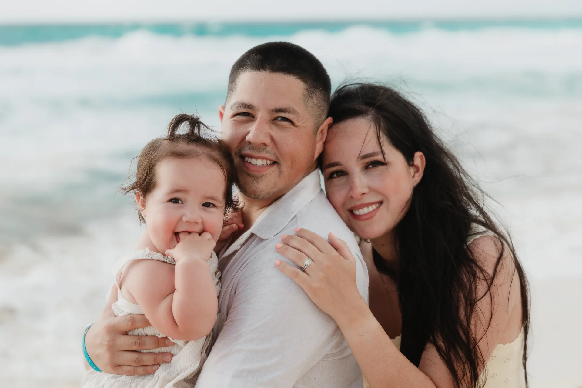 Family portrait with the ocean behind them, Playa Delfines, Cancún