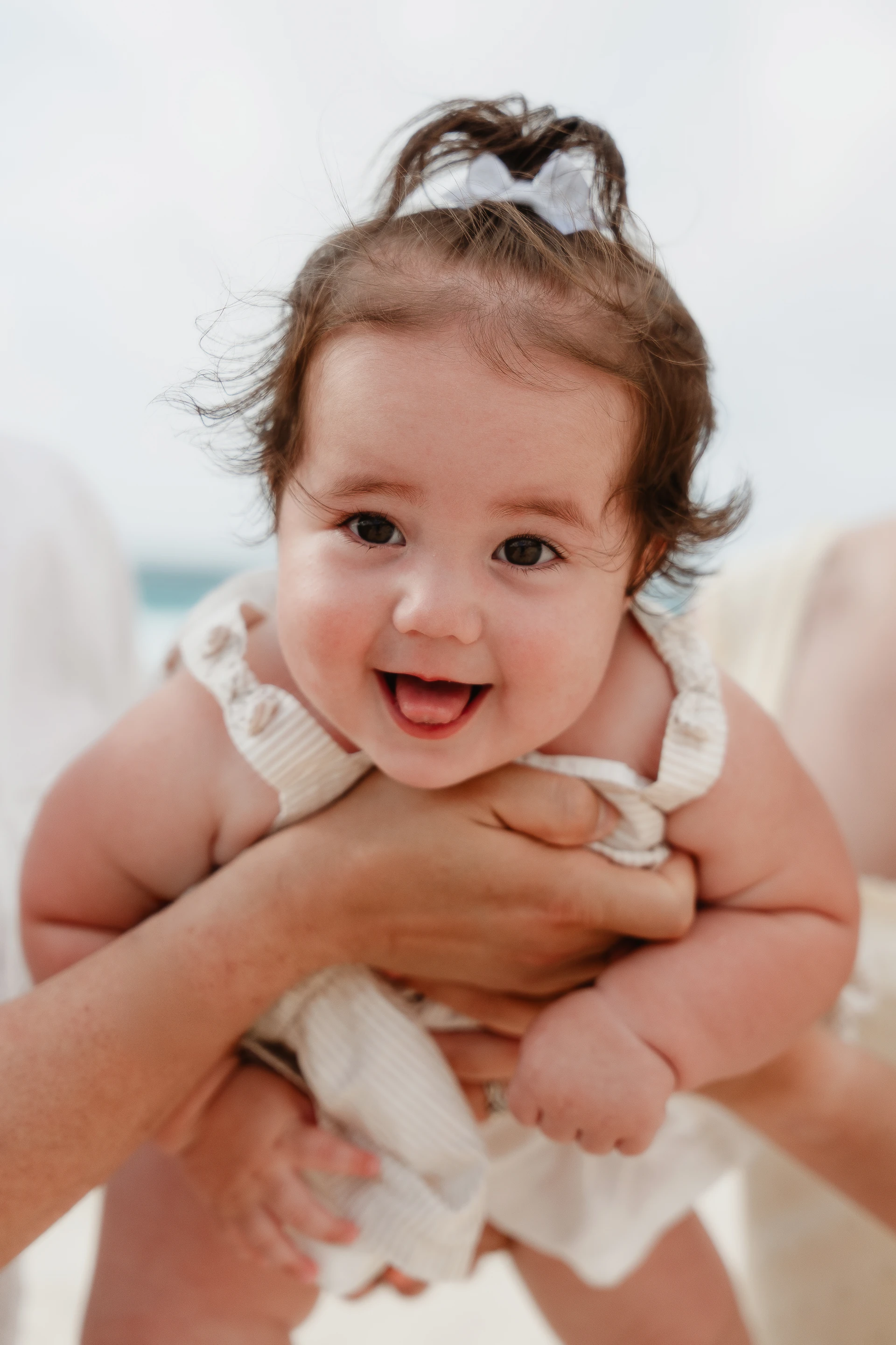 Smiling baby held up on a Puerto Morelos beach