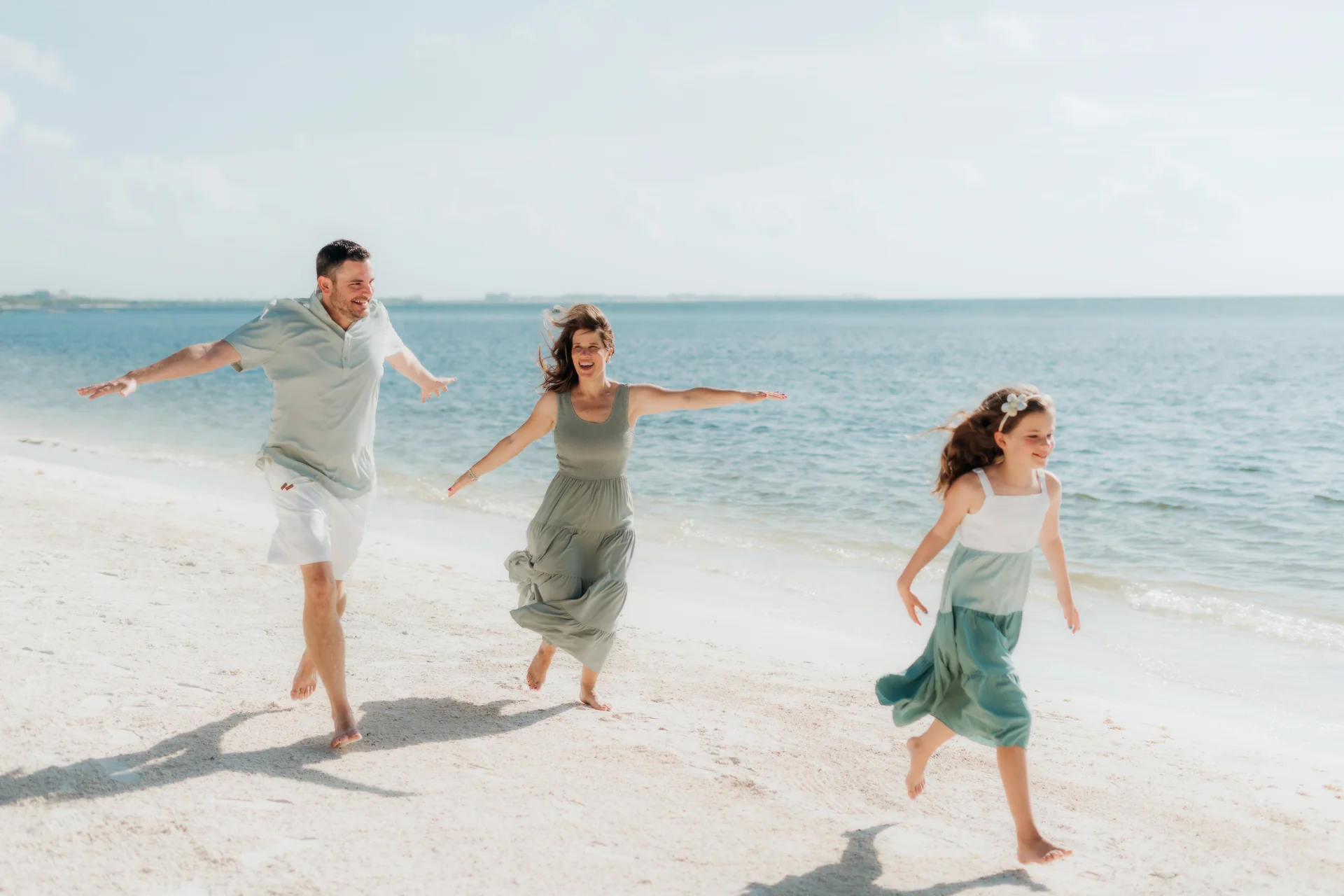Family gathered on the sand in the early light, Rosewood Mayakoba, Riviera Maya