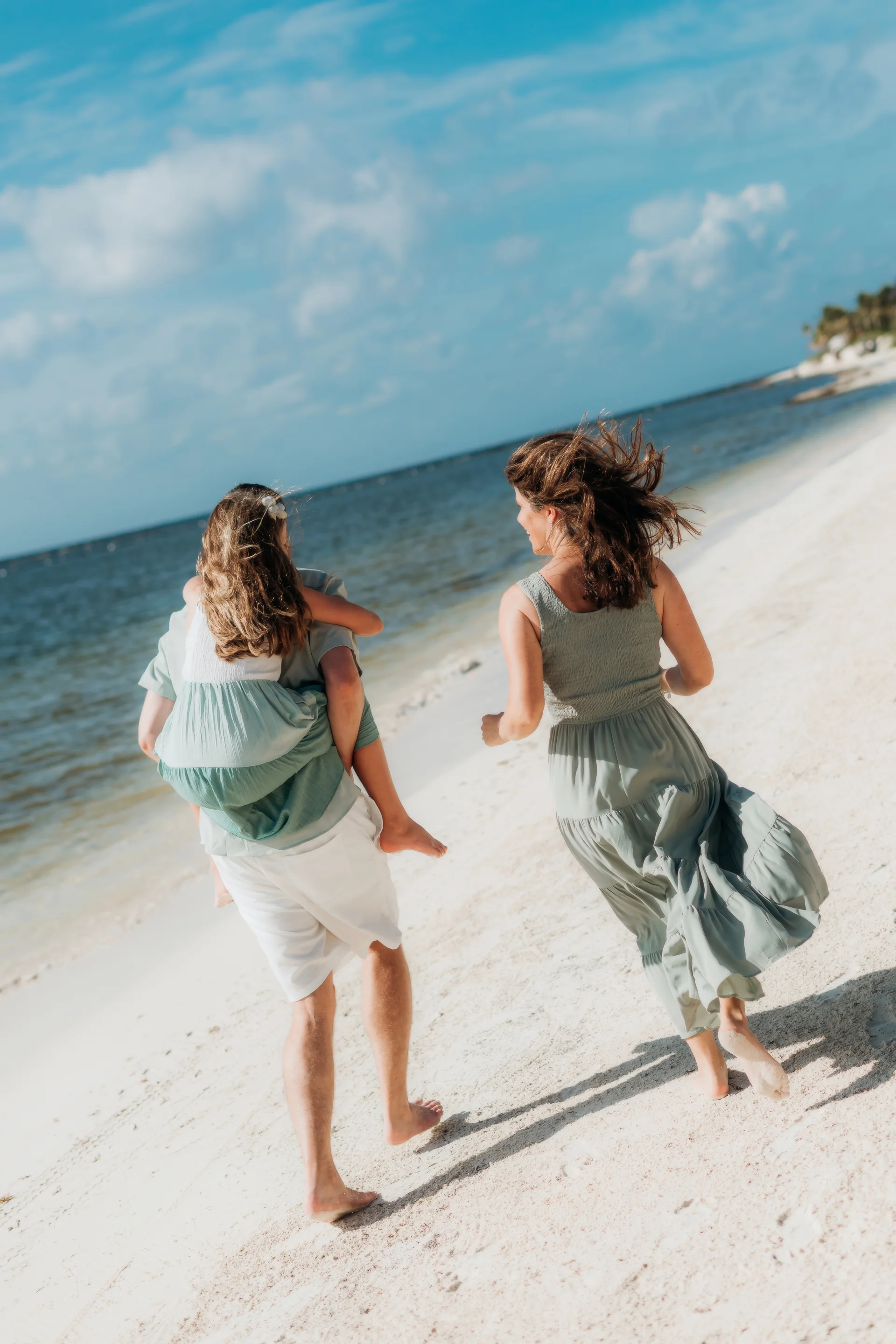 Family laughing together on the sand, Rosewood Mayakoba, Riviera Maya