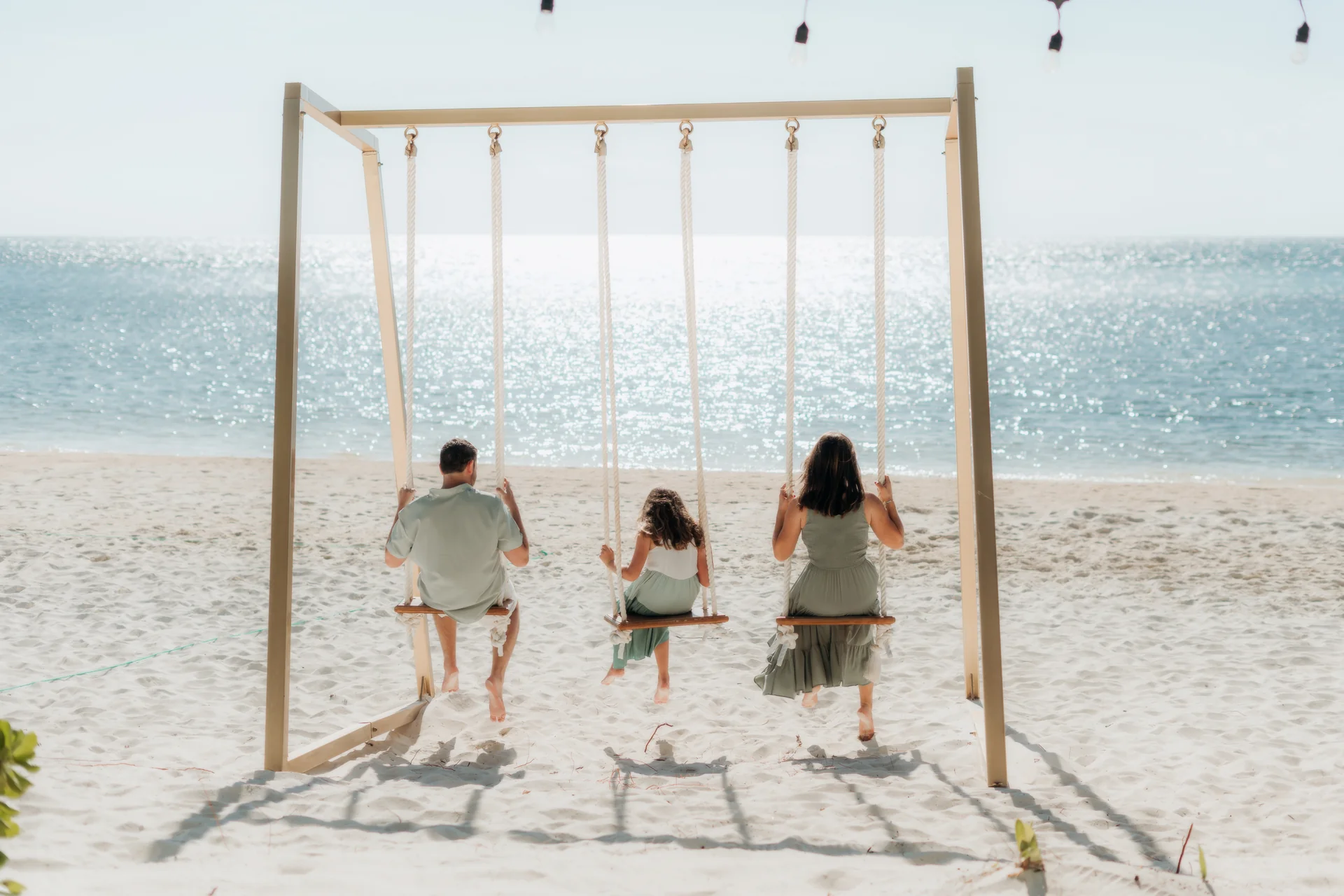 Family sitting together at the water's edge, Rosewood Mayakoba, Riviera Maya