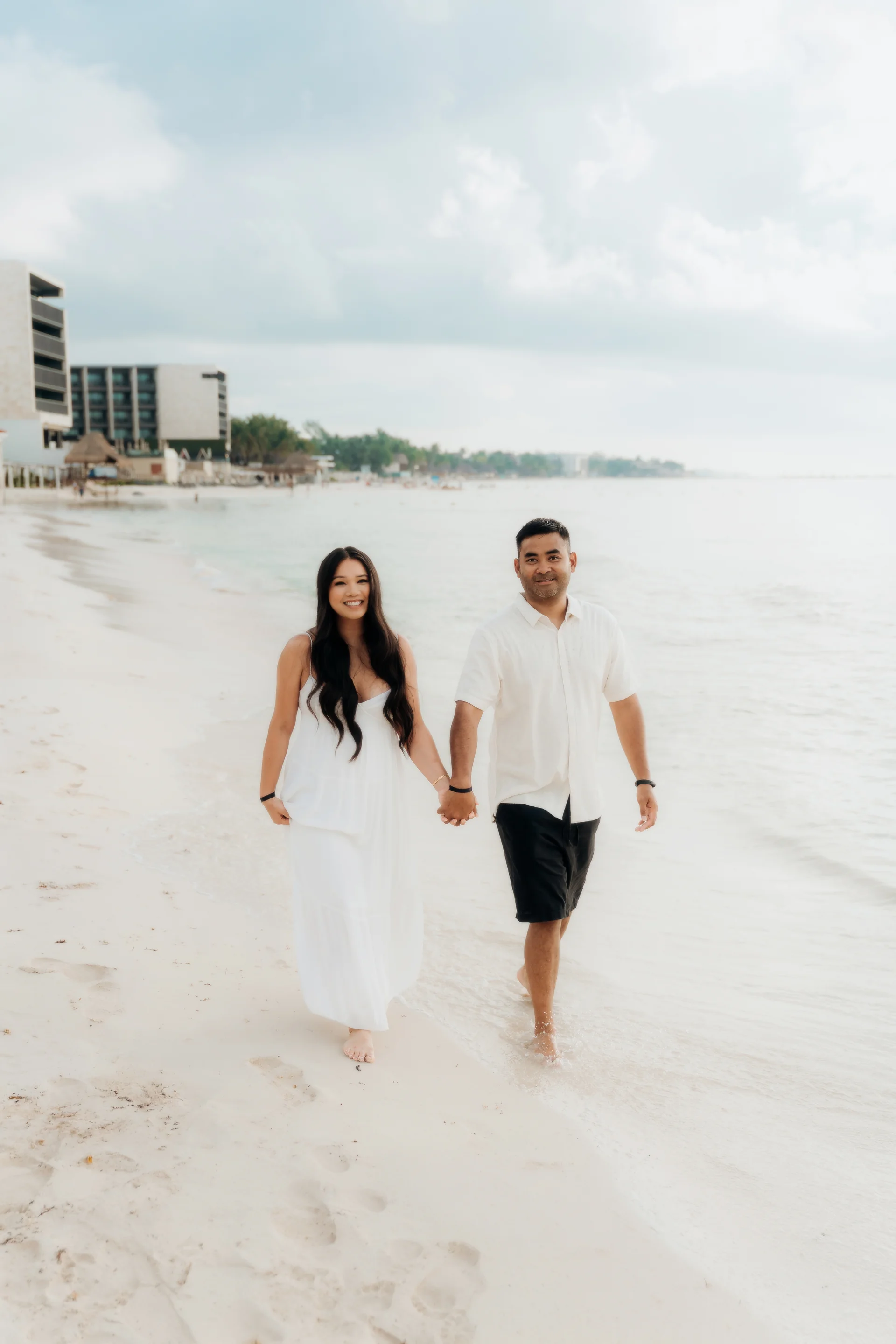 Couple walking toward the camera hand in hand at the water's edge, Hyatt Vivid, Playa del Carmen