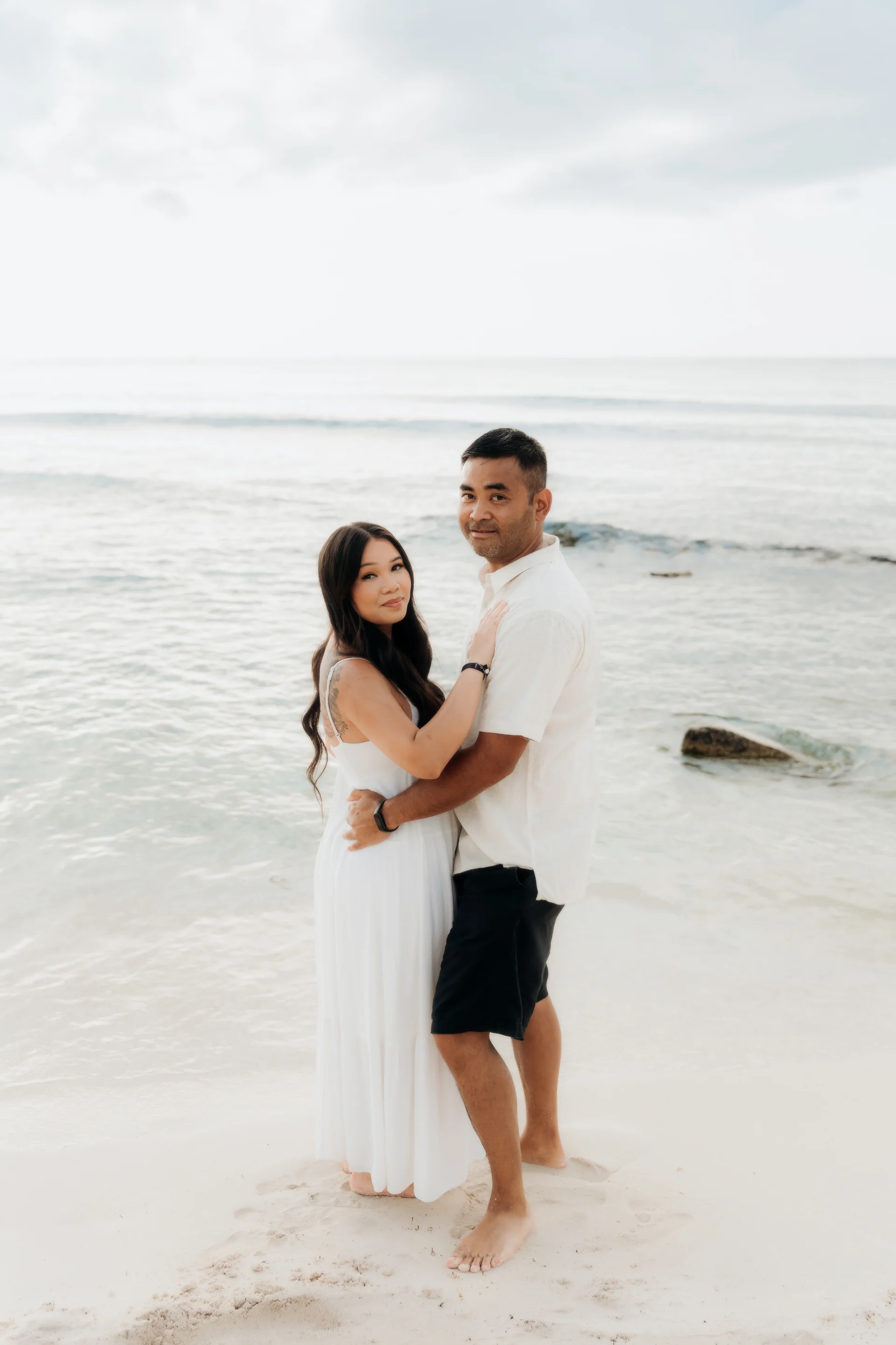 Couple embracing on the sand facing the camera with the sea behind them, Hyatt Vivid, Playa del Carmen