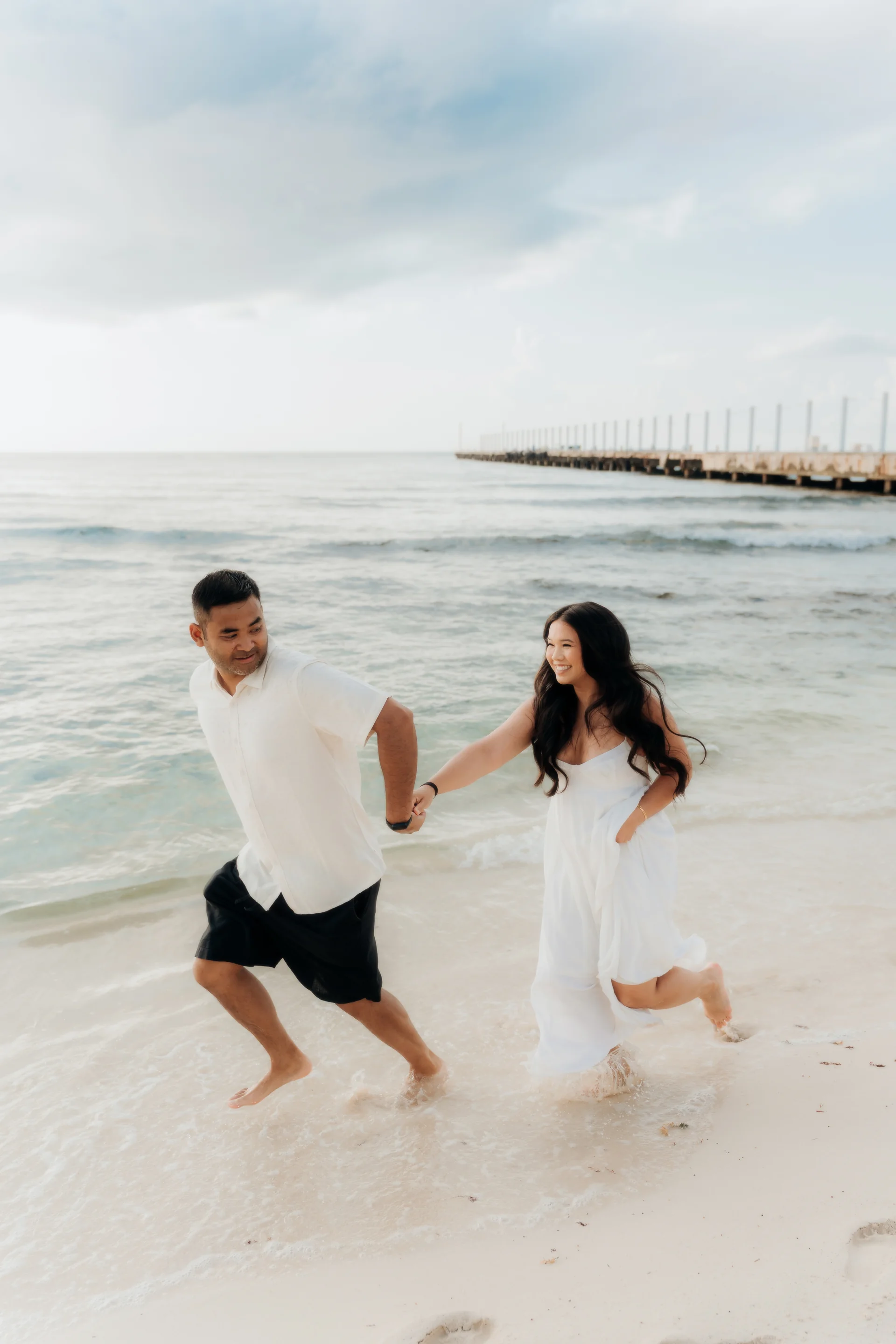 Couple running along the shoreline hand in hand and laughing, Hyatt Vivid, Playa del Carmen