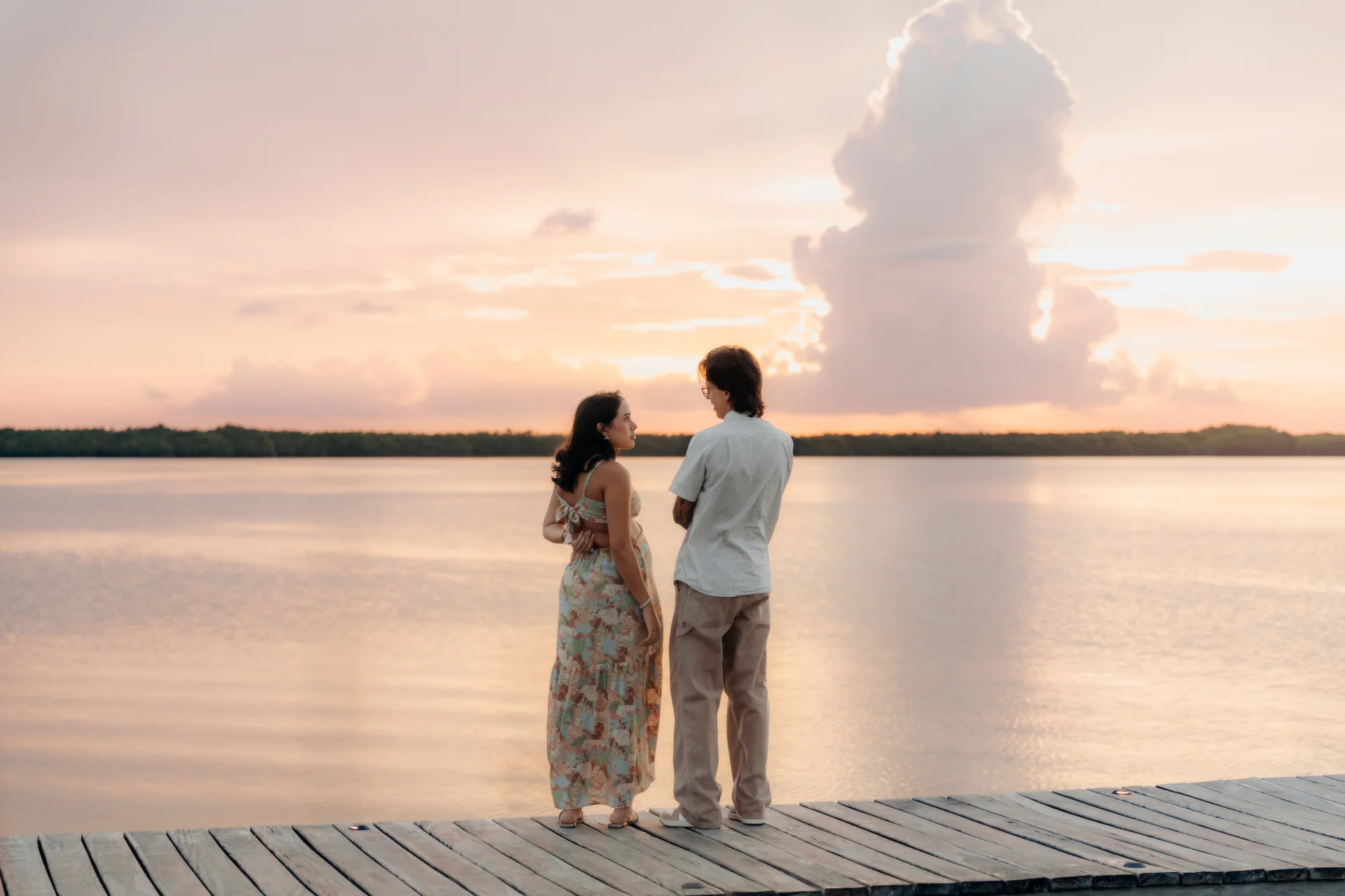 Expecting couple on the dock looking out over the lagoon at sunset, Navios restaurant, Cancún