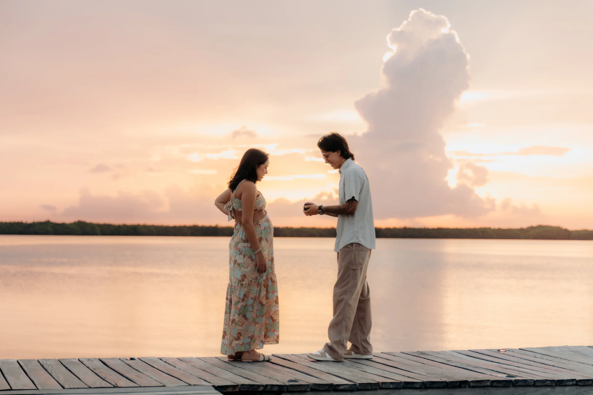 The proposal moment on the dock as he opens the ring box at sunset, Navios restaurant, Cancún