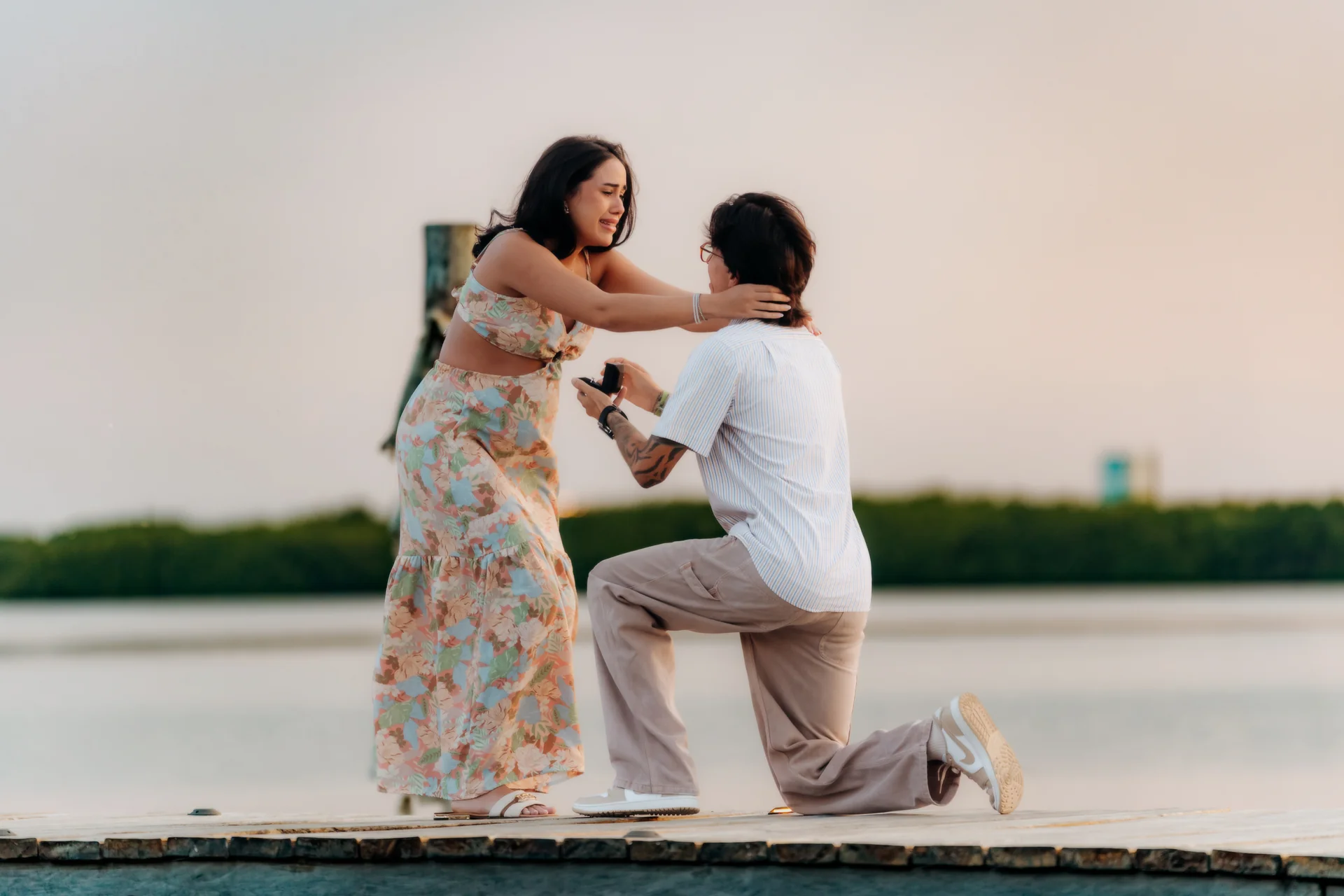 Couple embracing at the water's edge after saying yes, Navios restaurant, Cancún
